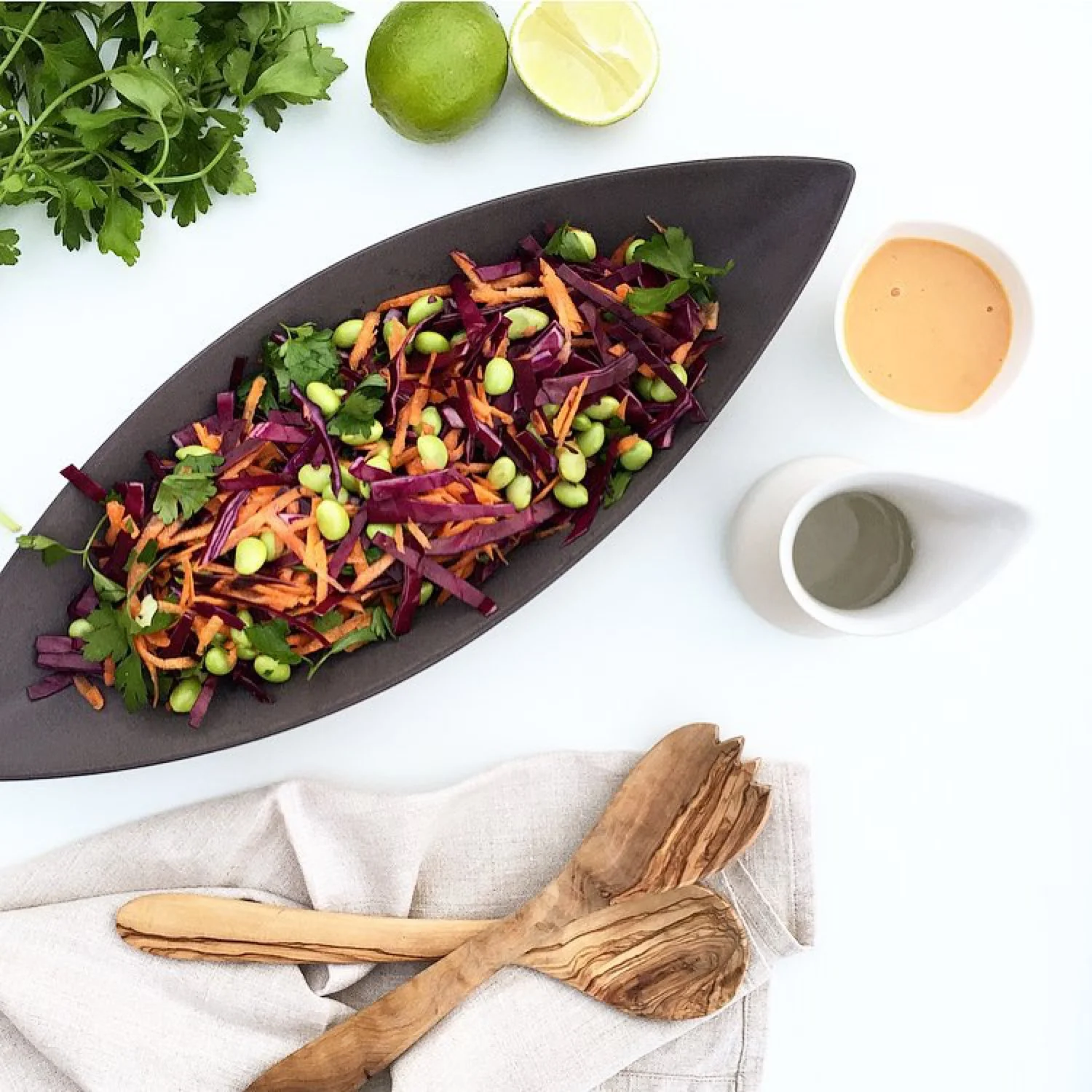 Sculptural boat bowl with raw salad on white table