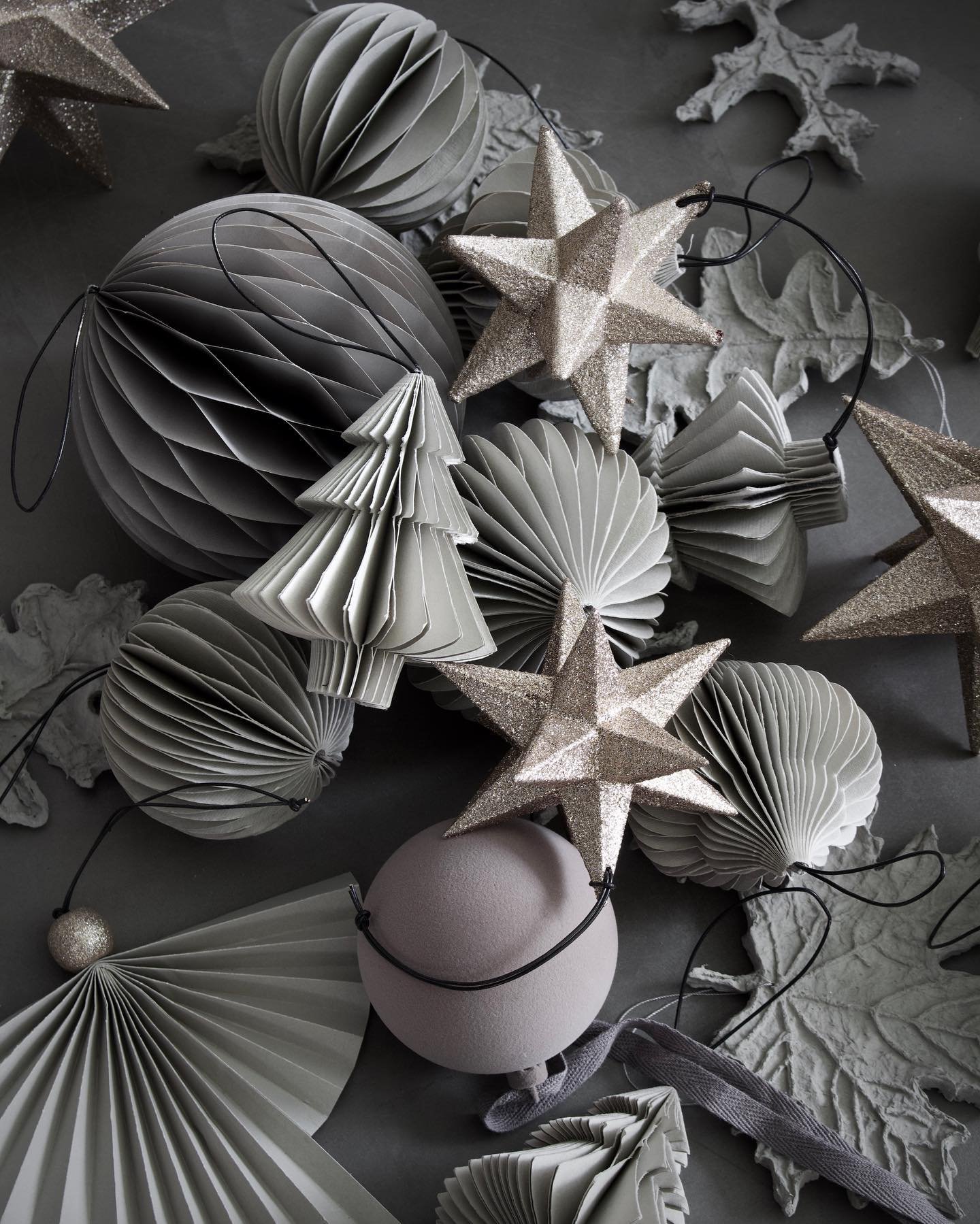 Grey folded paper ornaments on grey table