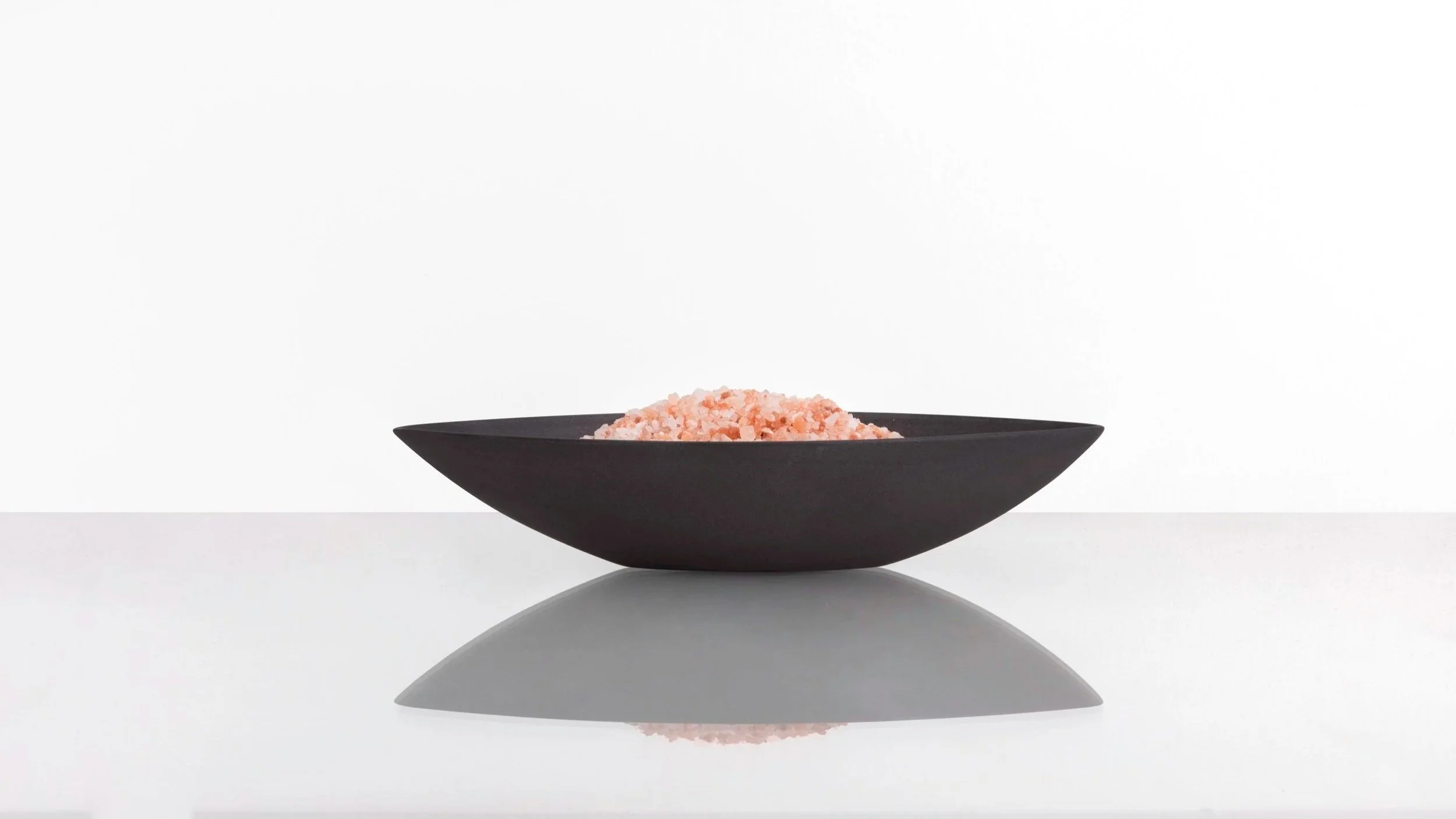 Handmade Danish porcelain Boat Bowl filled with pink salt on a neutral table