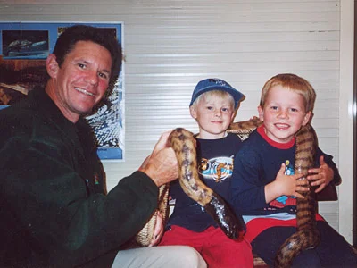 Edan and Angus were all smiles when Steve and Leroy the Black-headed Python paid them a visit, at the Rainbow Cottage Child Care Centre in Woolgoolga, Northern N.S.W. in 2004.