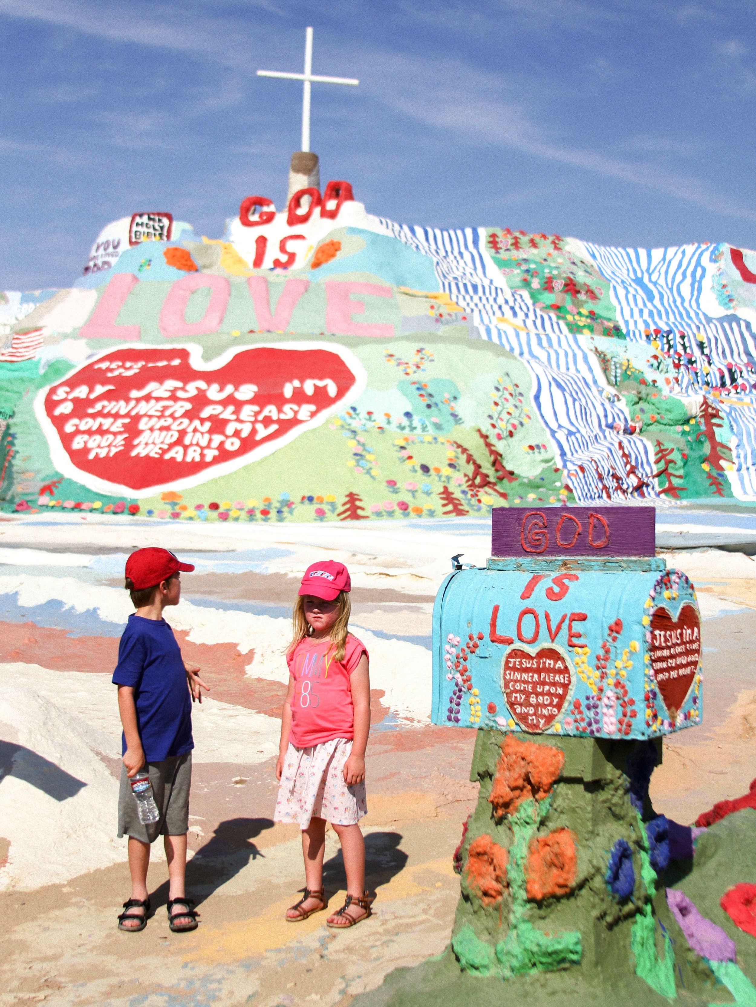  Two children wait for their parents to take their picture on Tuesday, July 29, 2014, at Salvation Mountain in Niland, Ca. Salvation Mountain is a man-made mountain created by artist Leonard Knight and is based on the Christian term,&nbsp;"Sinner's P