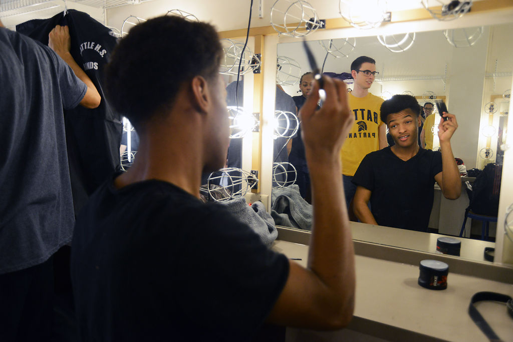  Battle senior Marlin Allen combs his hair before performing at the charity concert benefiting Children's Grove on Thursday. Allen is a part of Battle's show choir group Battalion, a mixed choir.    