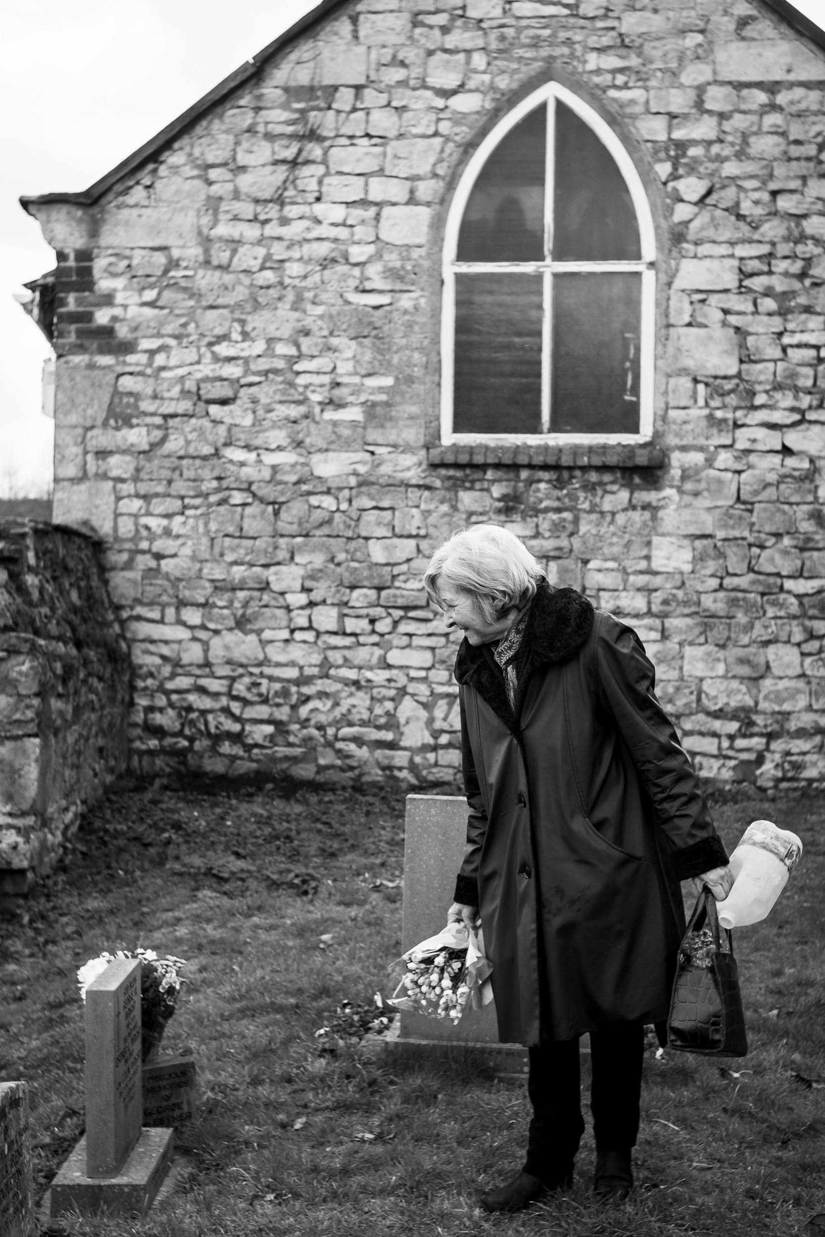 Mum laying fresh flowers on her parents grave