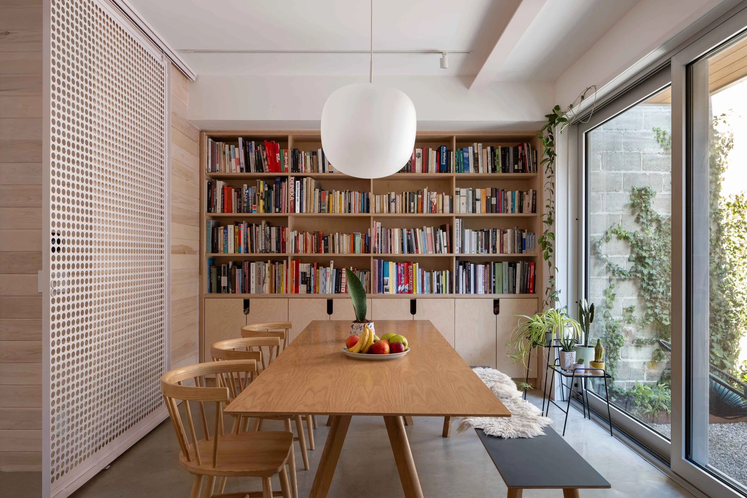 Modern dining room interior inside a Toronto laneway house highlighting warm finishes and custom Baltic birch millwork
