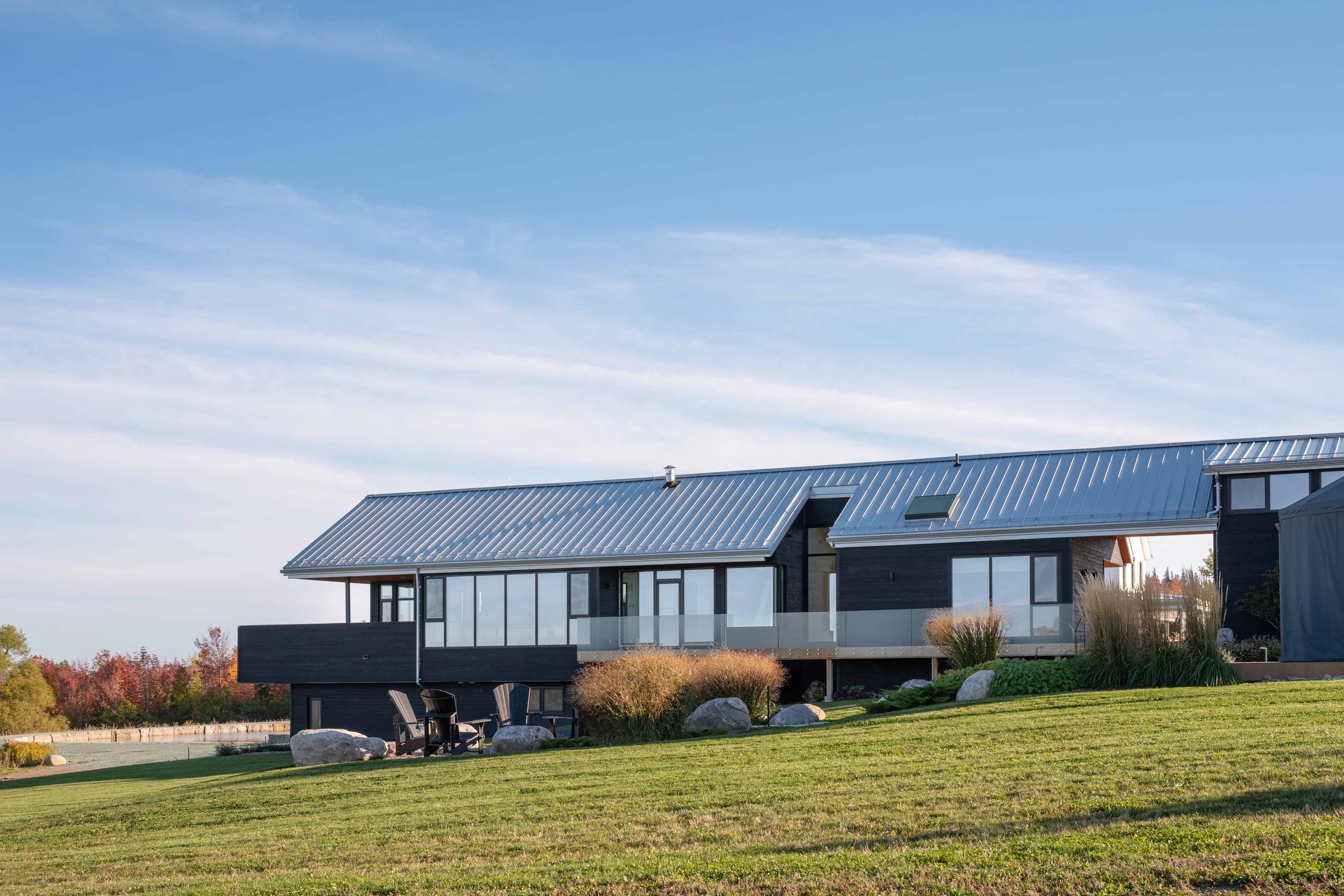 Modern country house exterior architecture inspired by traditional Ontario barns and vernacular rural design structures.