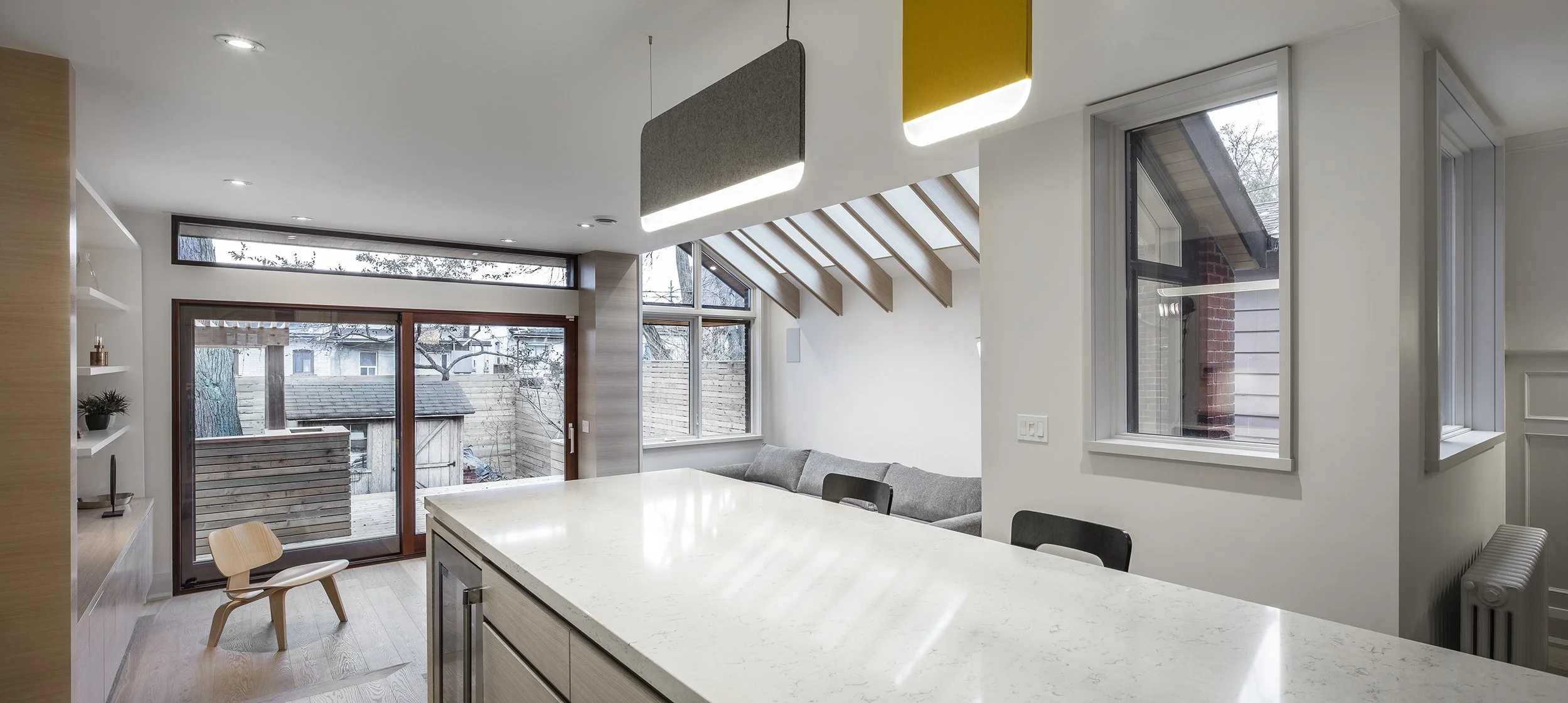 Open concept kitchen renovation featuring custom architectural skylights, modern white cabinetry, and abundant natural light