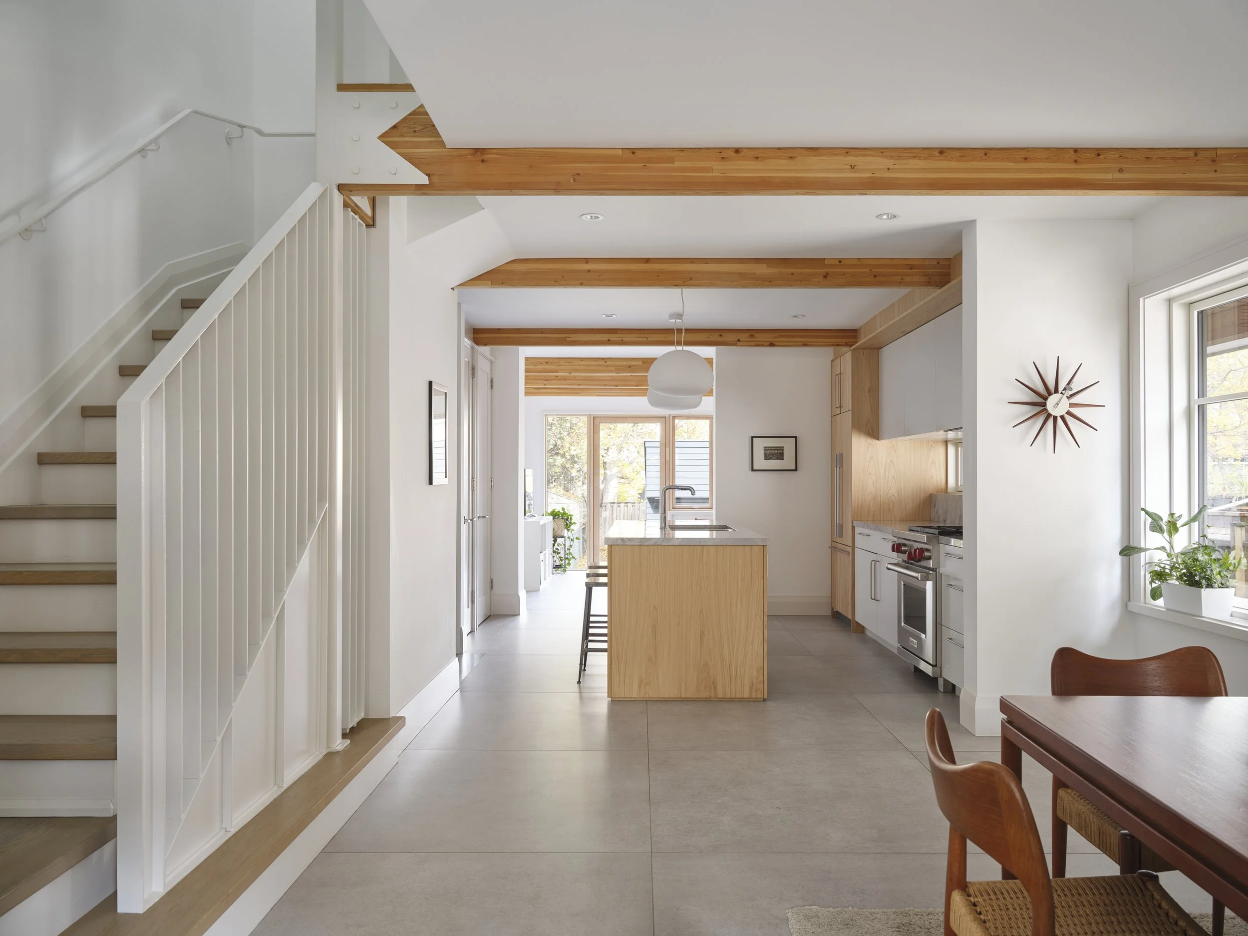 Open concept dining room showing architectural flag steel accents and structural wood glulam beams.