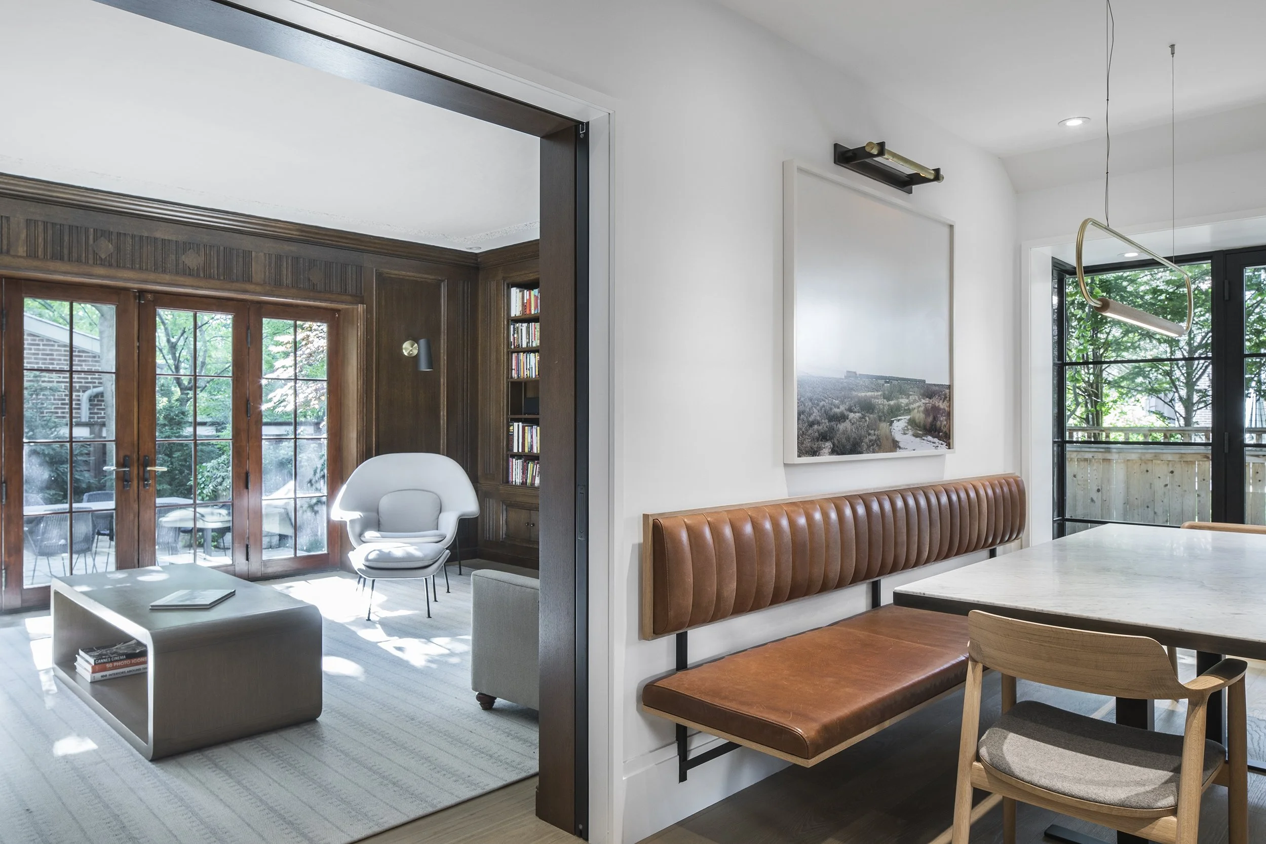 Built in custom wood dining banquette paired with updated contemporary heritage wall panelling in a Toronto home renovation.