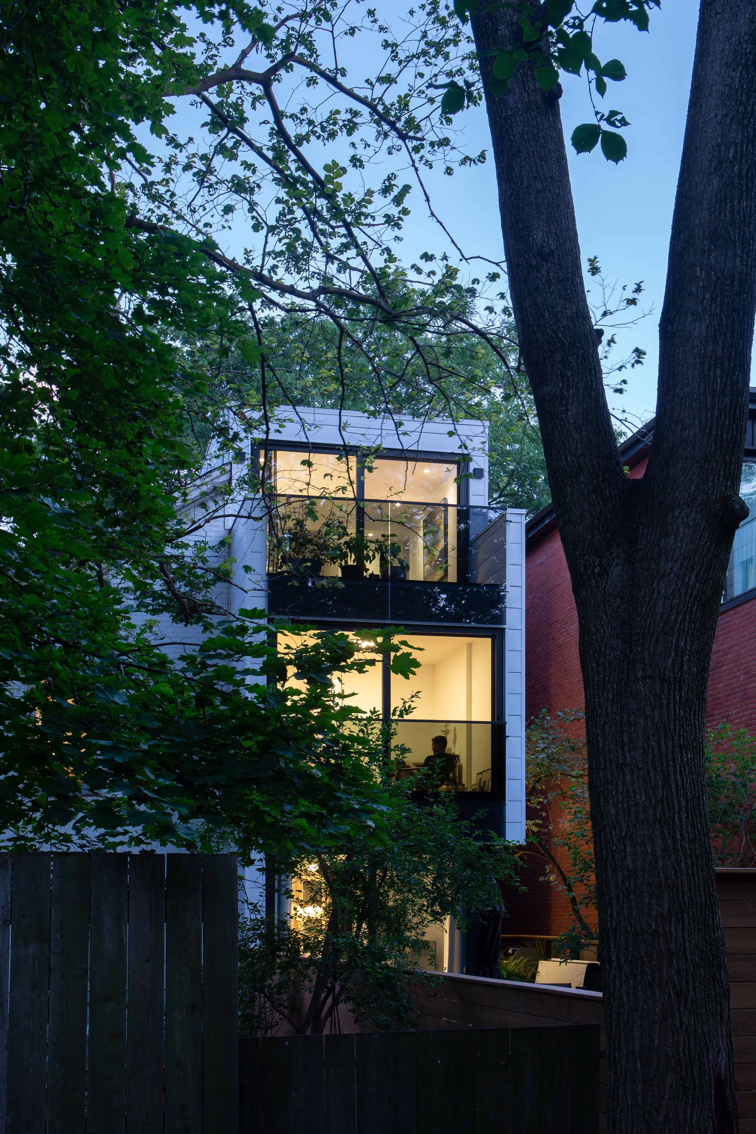 Three storey glassy modern residential home extension in Toronto by Wayback Architects.