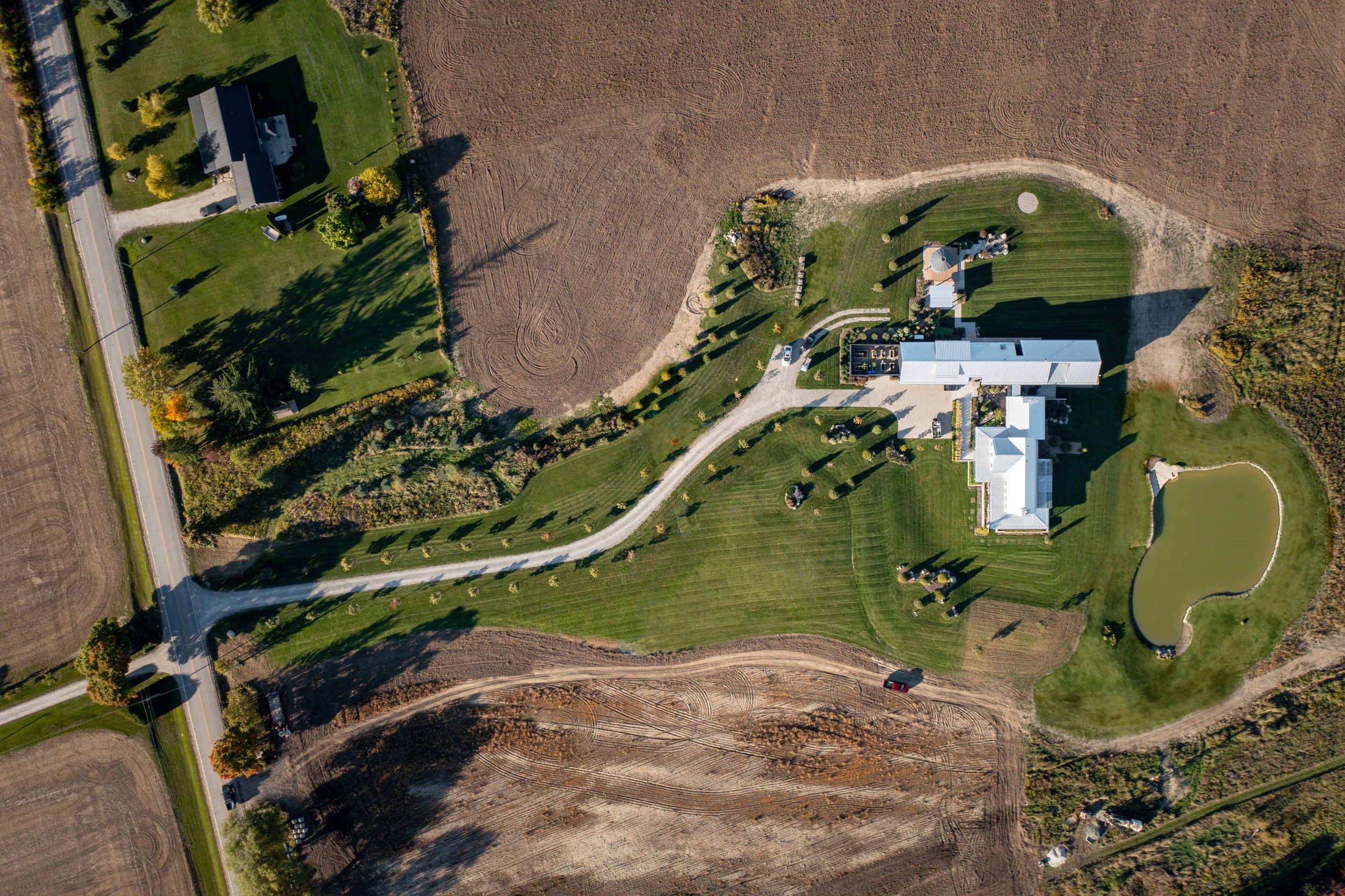 Aerial view of Vardegaard, a modern custom farmhouse designed by Wayback Architects nestled into the rolling hills of Creemore, Ontario.