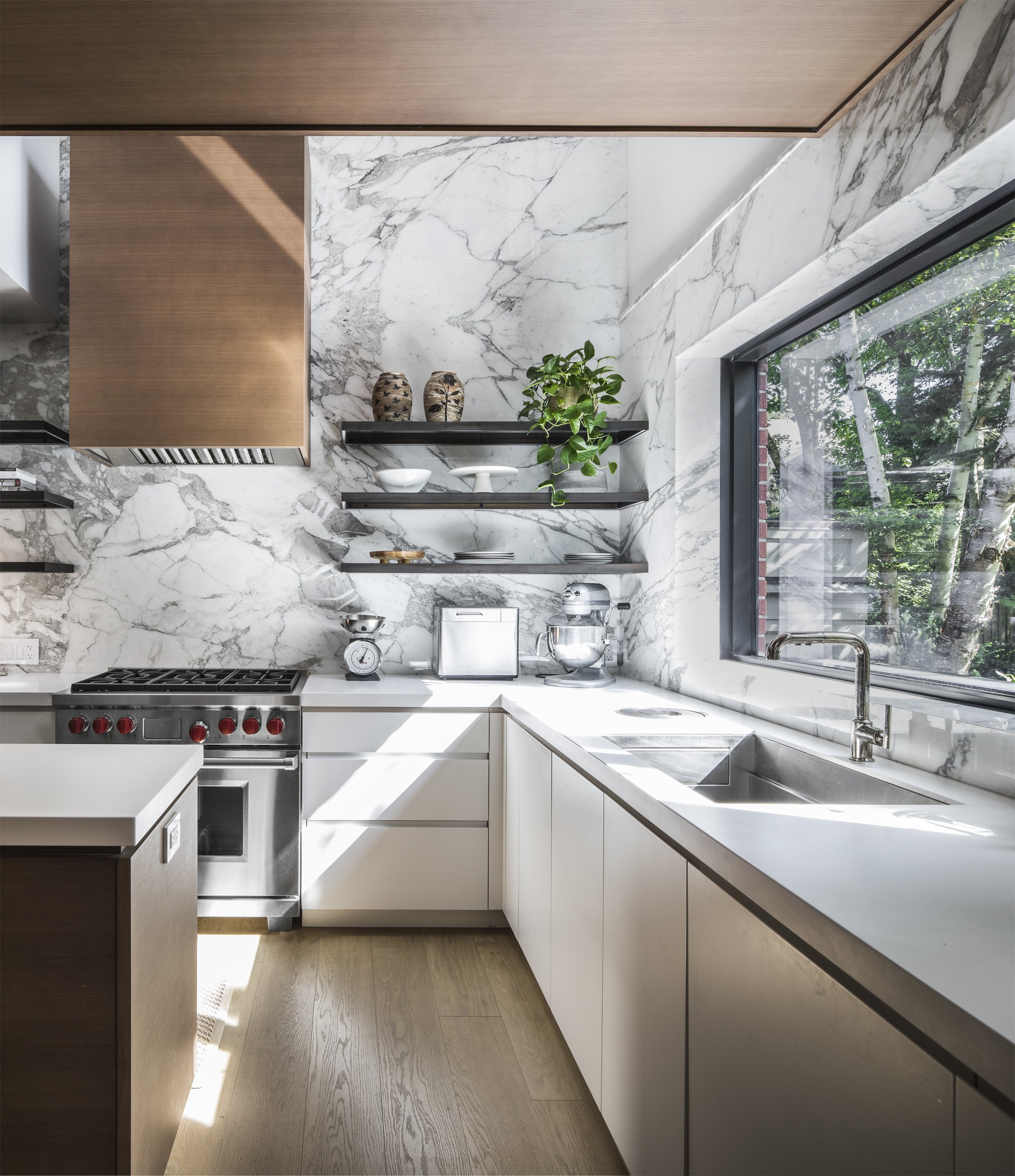 Bright open concept kitchen design featuring custom wood cabinetry and an architectural lightwell throwing natural daylight deep indoors.