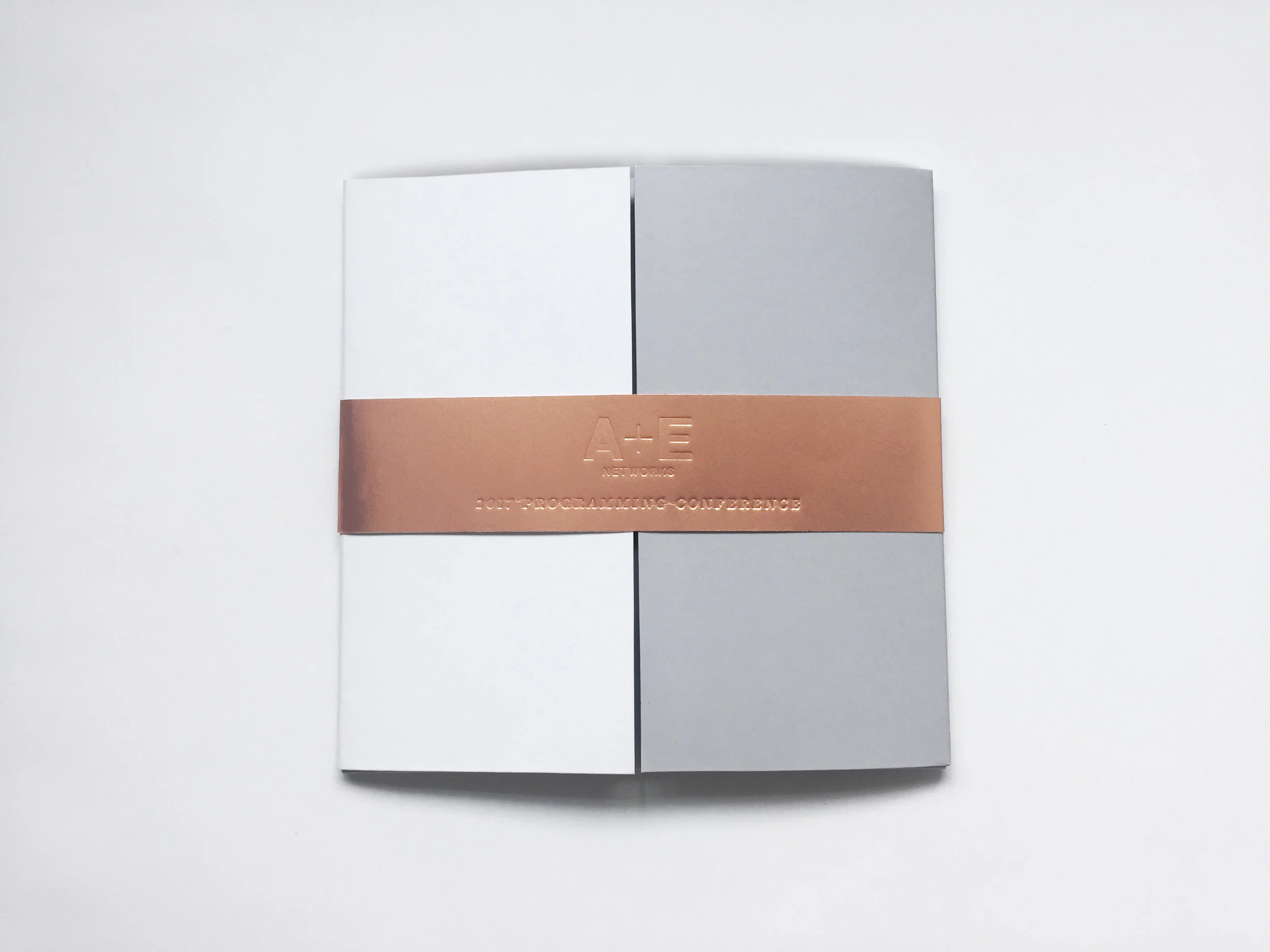 Premium, custom designed invitation for top-level executives invited to annual Programming Conference. The invitation incorporates the new look and feel of the recently launched A+E Networks identity system, which is a higher-end, chic look. Rose gold stamping and blind debossing on premium paper were used to achieve the higher-end look and feel. 