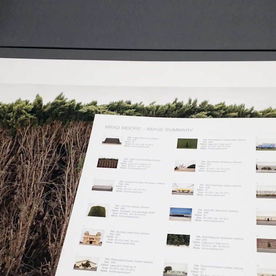 Color photograph of an opened portfolio box with photographs.