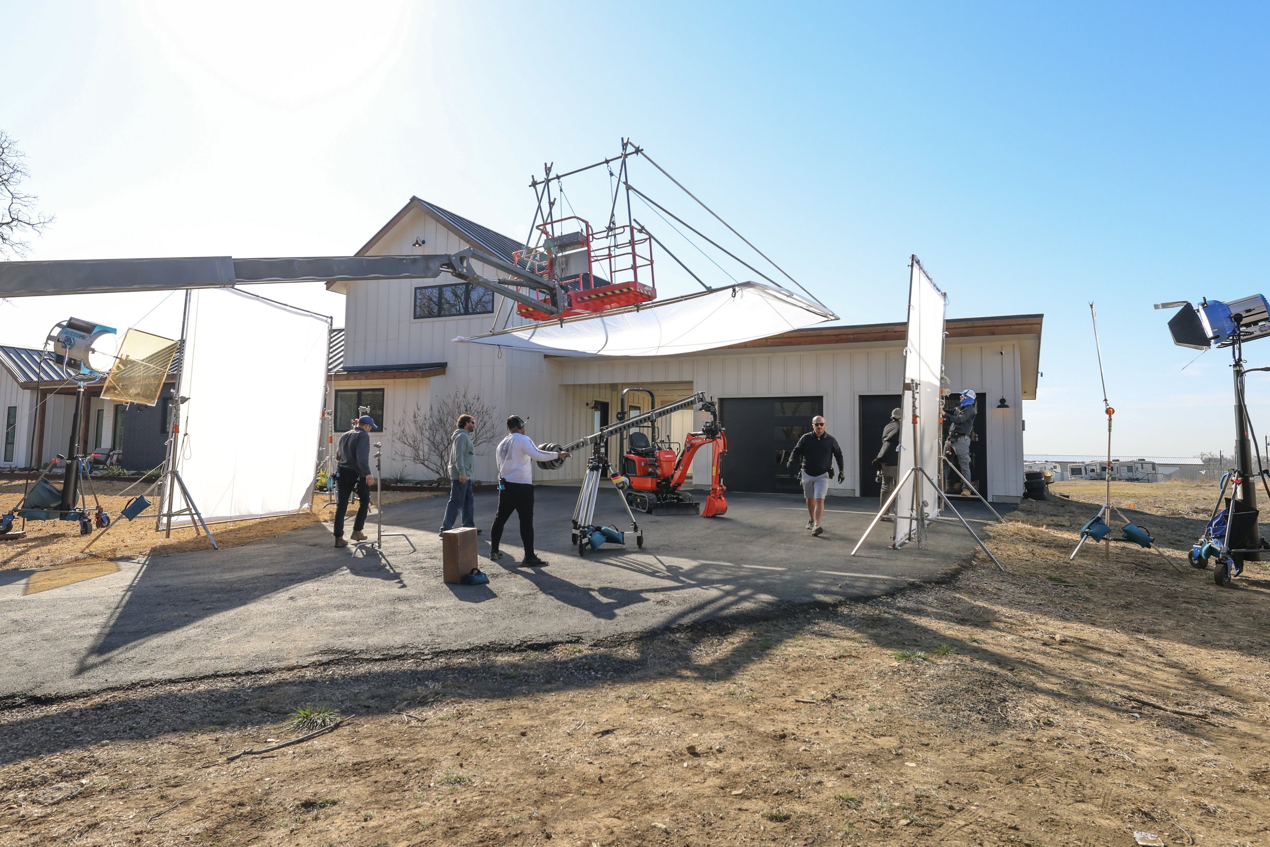 Crew and lighting outside a barn prepare a Kubota equipment video production.