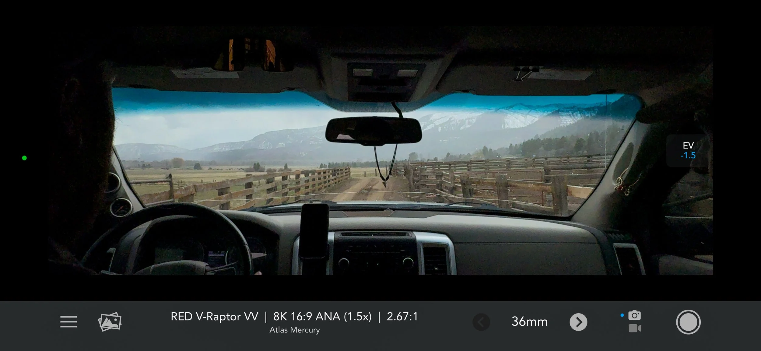 A view across ranchland from inside a vehicle appears on a production monitor.