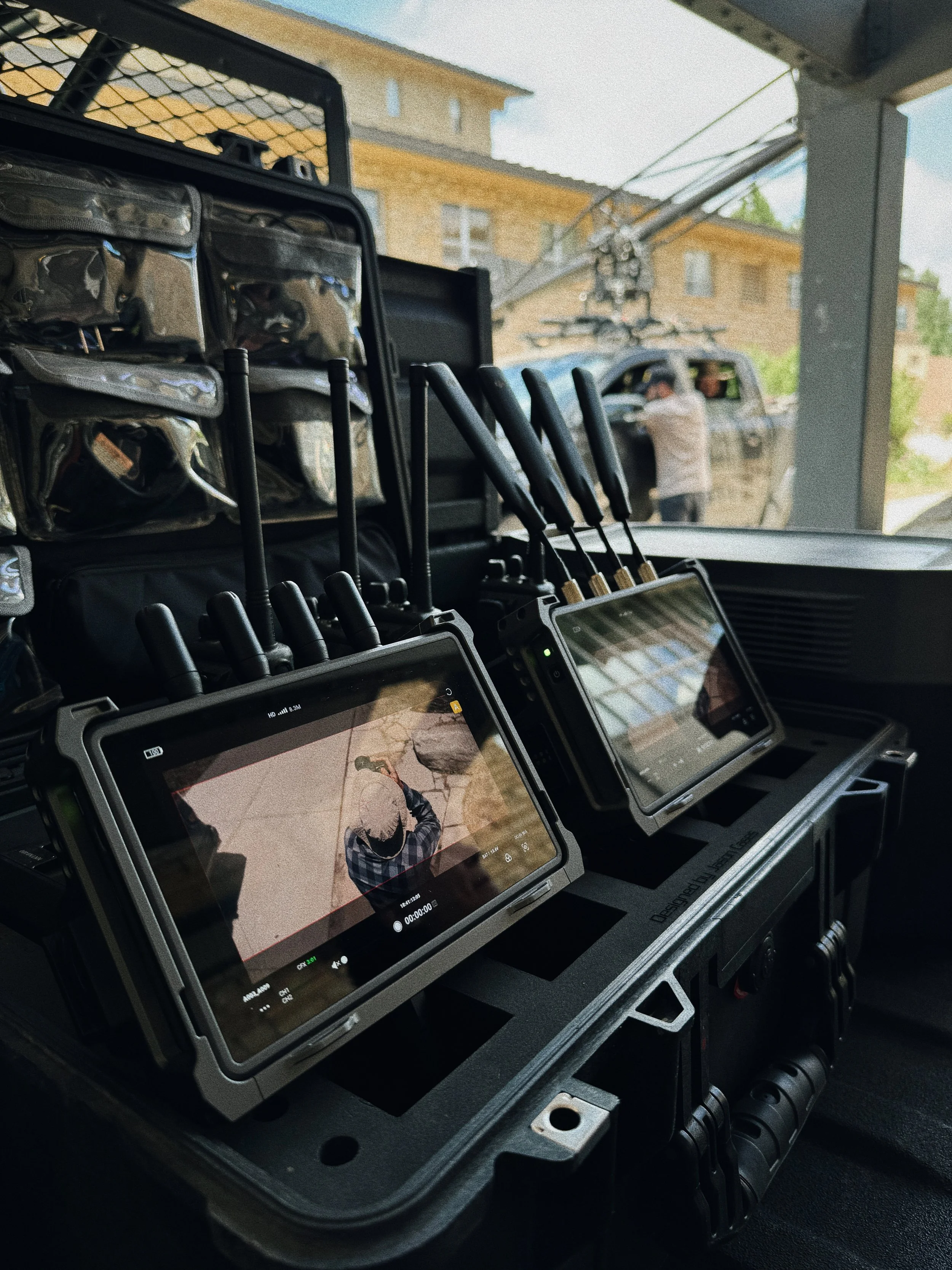 Production monitors display footage inside a utility vehicle during an equipment video shoot.