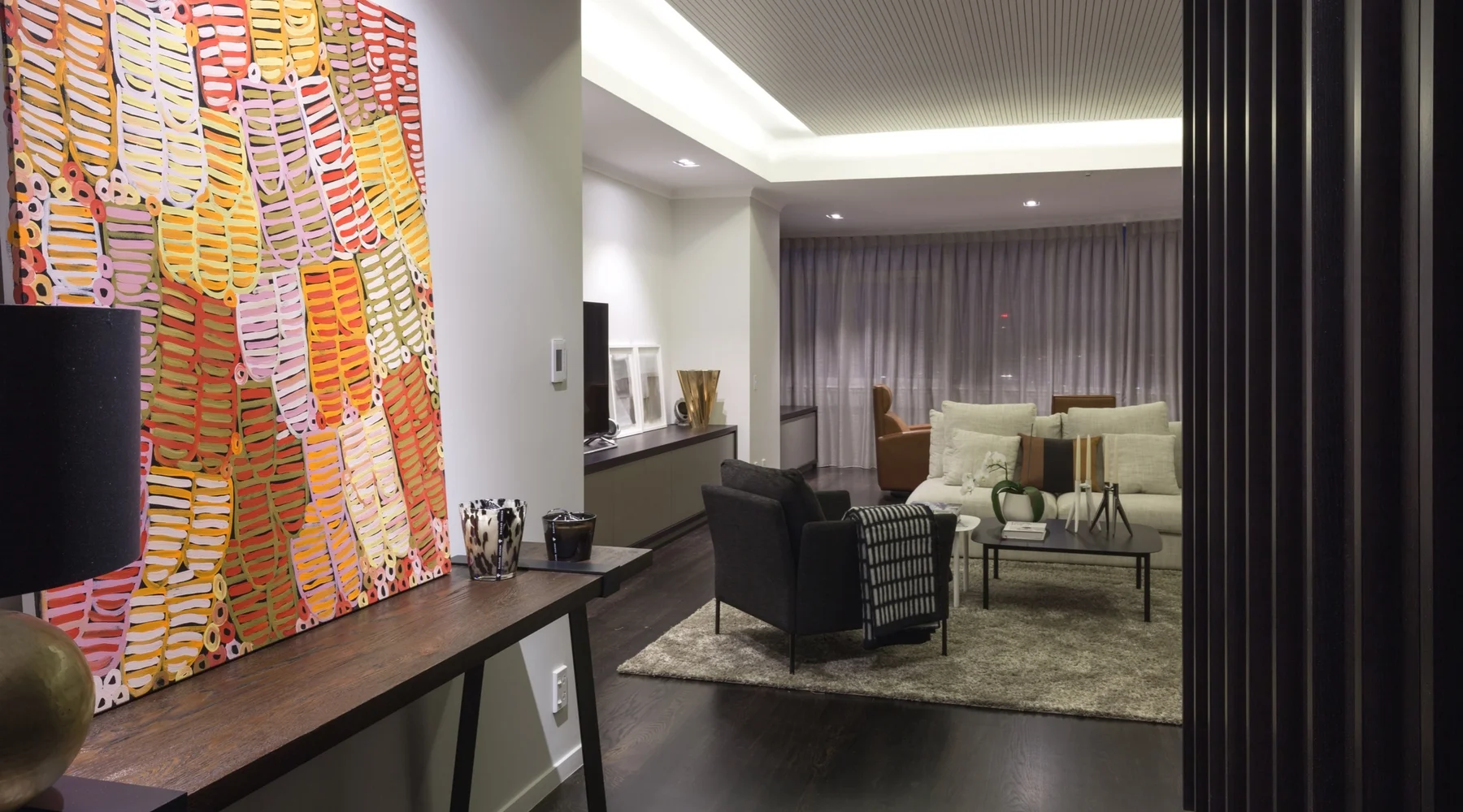 Dark wood features strongly throughout the apartment - on the floor, on wall features and on custom furniture.&nbsp;