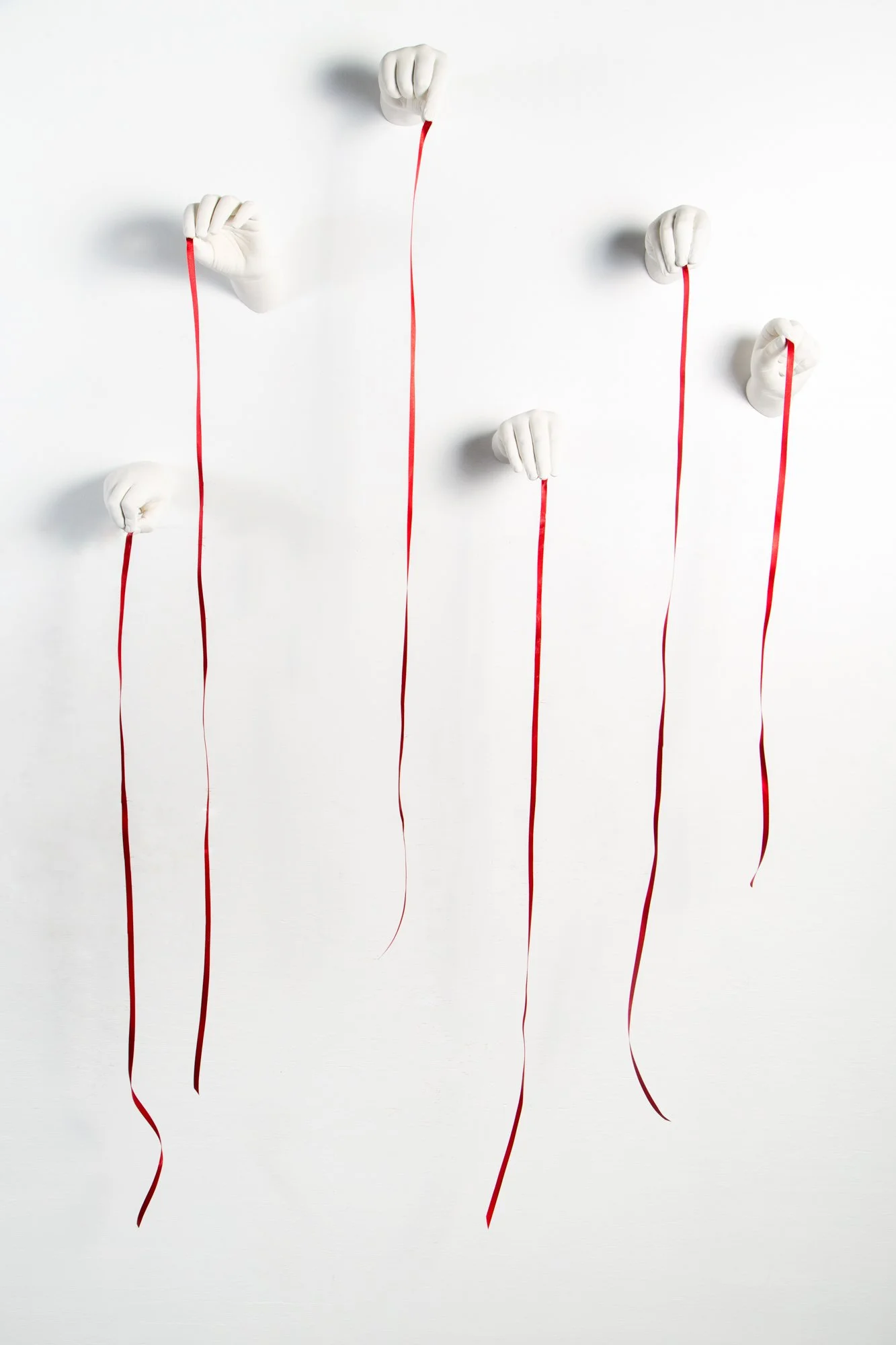 ariadne’s thread, 2025 plaster hands, red ribbon dimensions variable