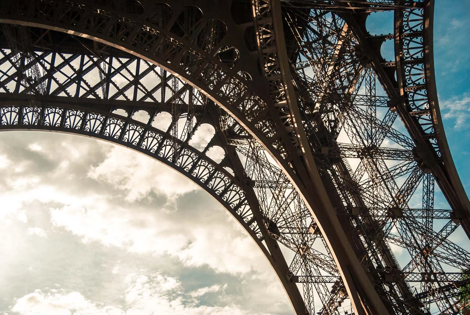 close up of the eiffel tower in paris on a beautiful summer day with blue sky and clouds Taken with a 50 mm Nikon lens