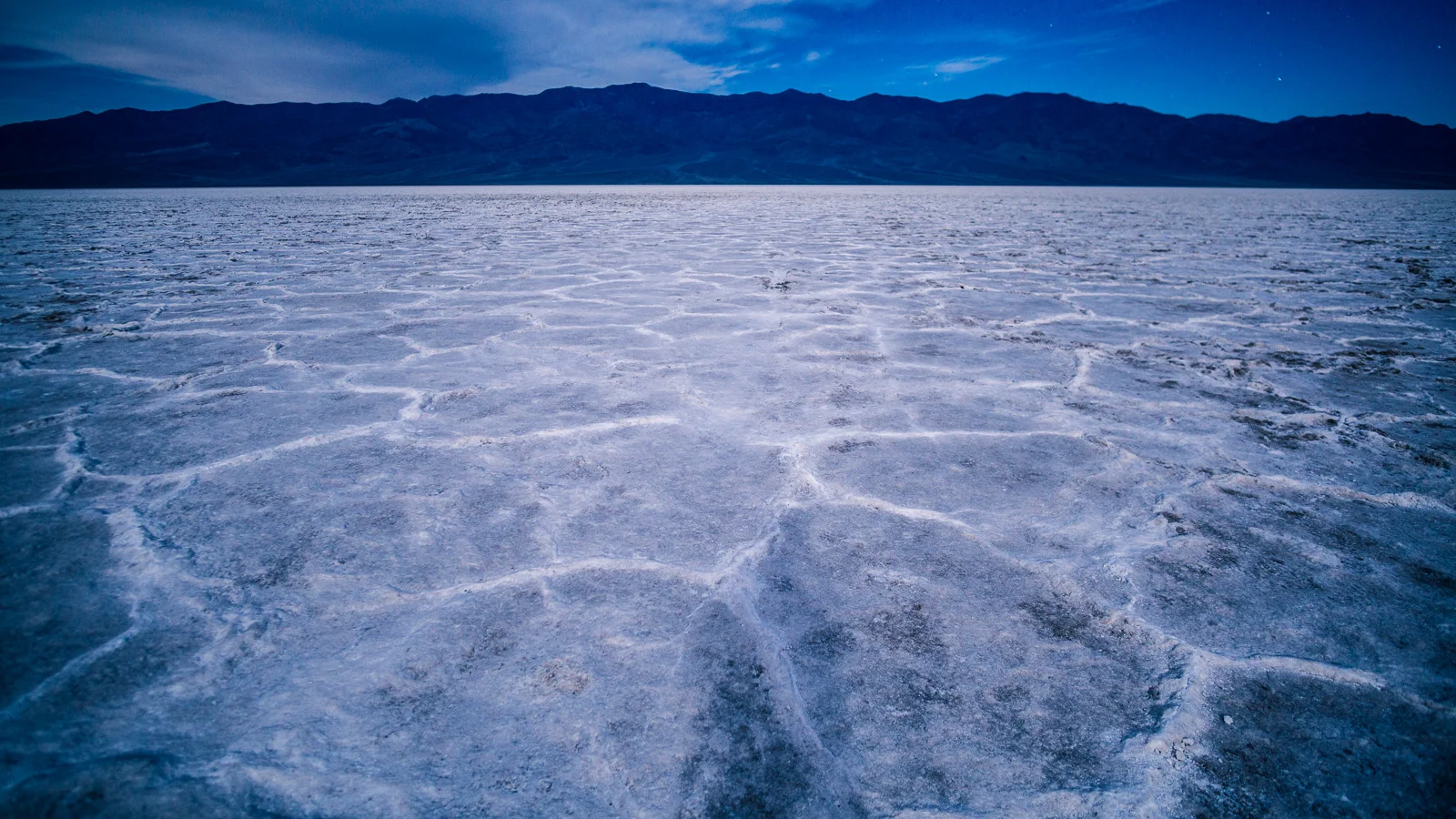 Landscape and desertscape photograph of the bad water basin salt flats in death Valley national park under a full moon