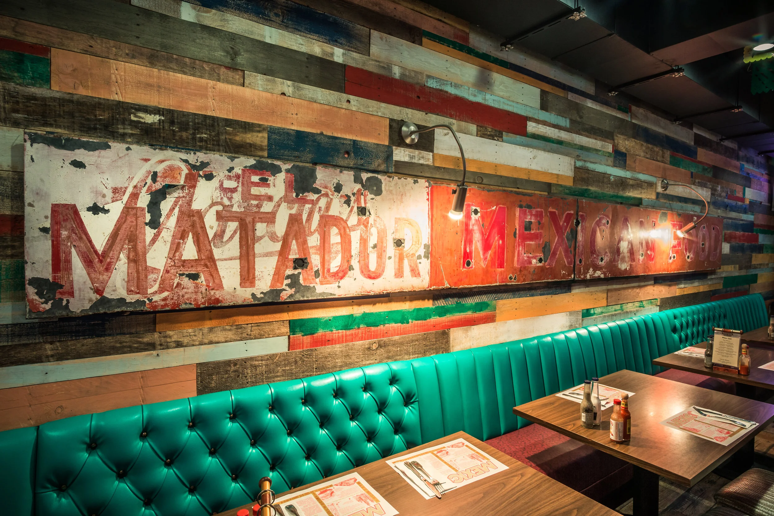 Interior photograph Of the Booth and table and Rustic wall art and light fixtures after Matador restaurants in Costa Mesa