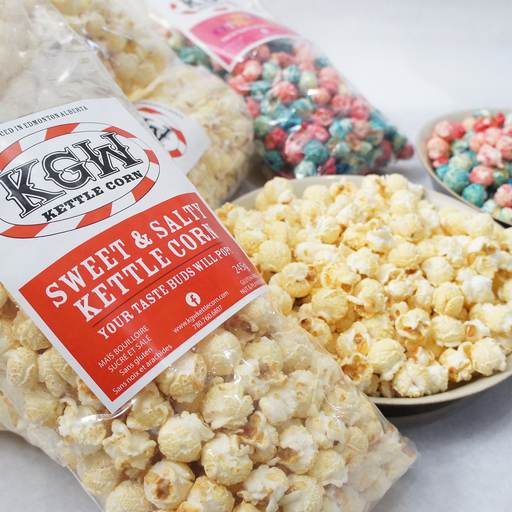 Bag of Kettle Corn labeled 'Sweet & Salty Kettle Corn' surrounded by bowls of popcorn and bags of colorful candies.