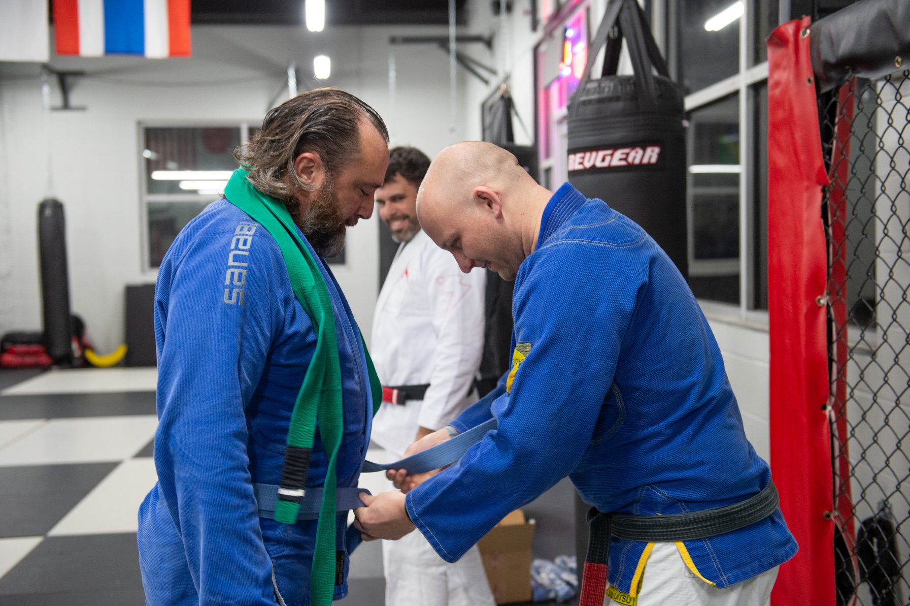 Photo Credit; Joed Viera . Denis receives a blue belt in Jiu Jitsu from professors Josh Ketry (background) and Larry Backlas at Buffalo United Martial Arts .