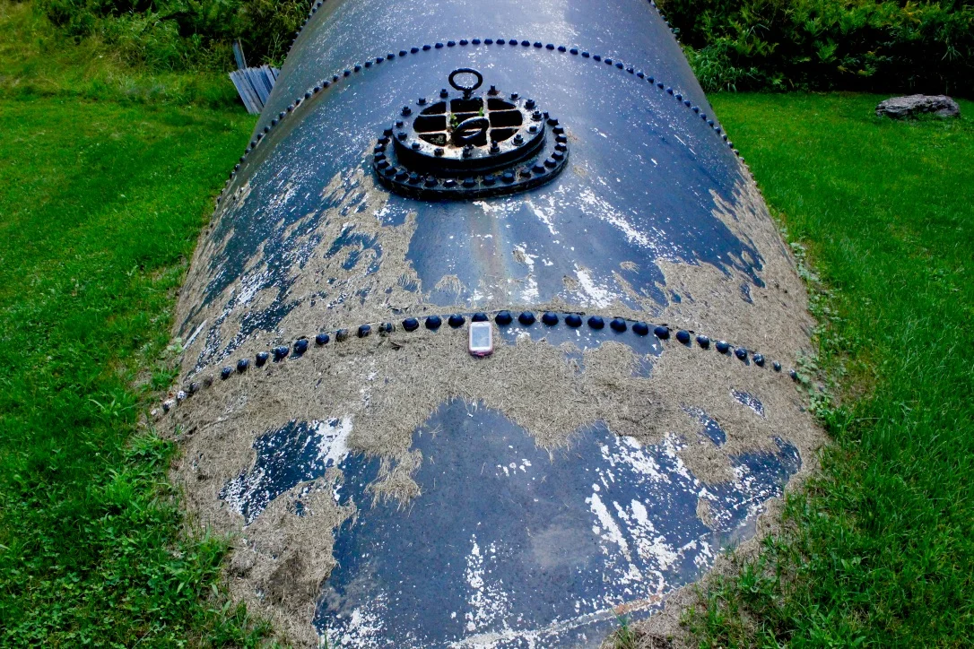 Iphone 5s on pipe going into the ground and power station.
