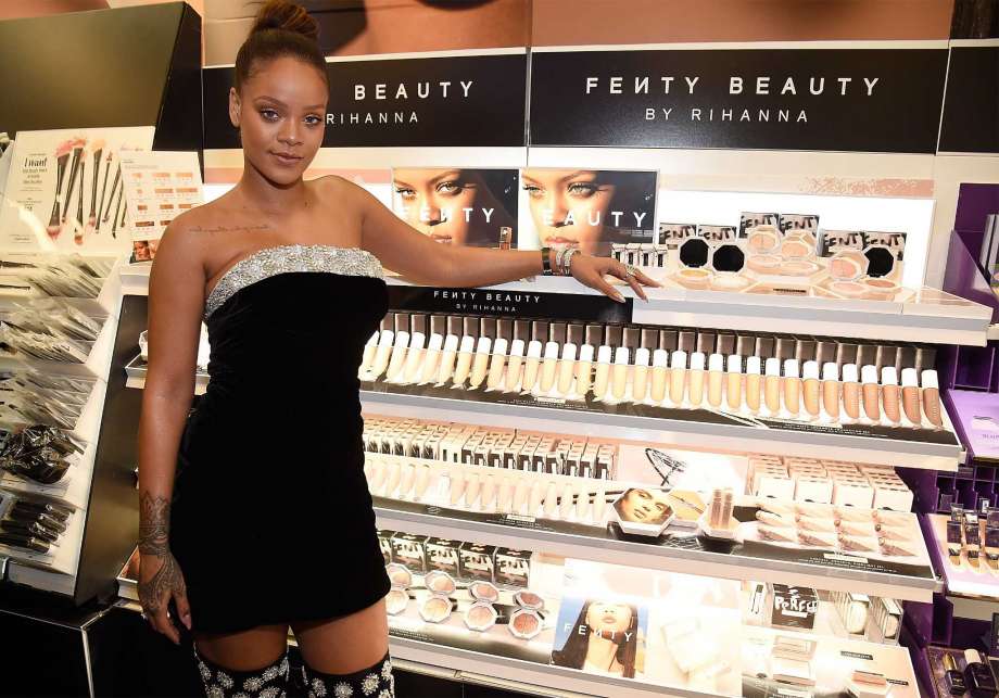 Rihanna next to a Fenty Beauty display, photo via Kevin Mazur