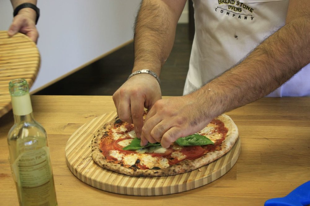 Putting basil on the pizza.