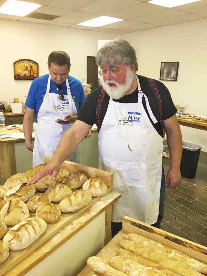 Man arranging baked loaf bread.