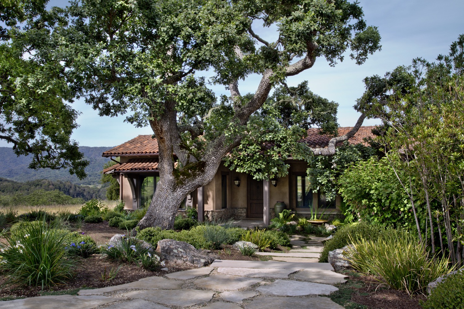 One of the landmark oaks shades the entrance to the home.