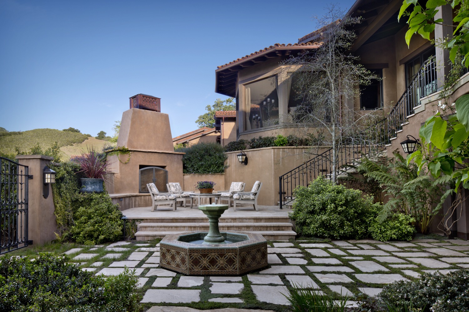 On the opposite side of the home from the pool, a sunken courtyard provides continual shade and a fireplace.