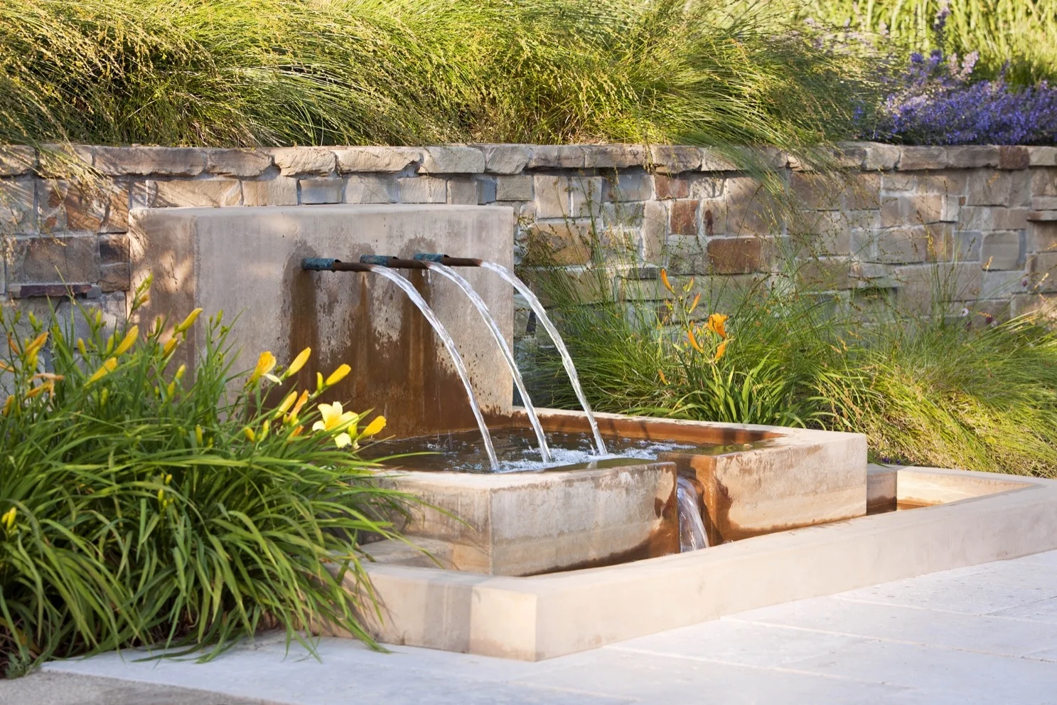 A second fountain provides the soft sound of falling water near a gathering area.