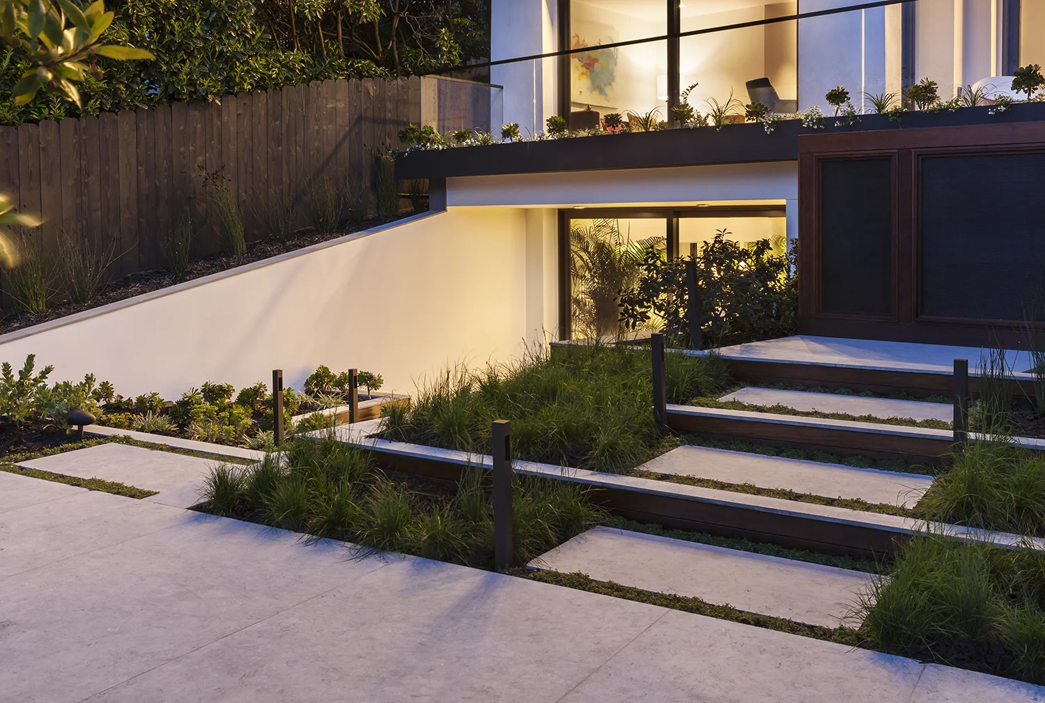 The lowest level is connected to the garden through plantings and a continuation of materials.