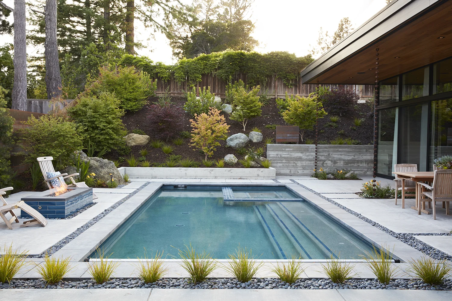 The back of the yard ends in a gentle hill, dotted with Japanese maples.
