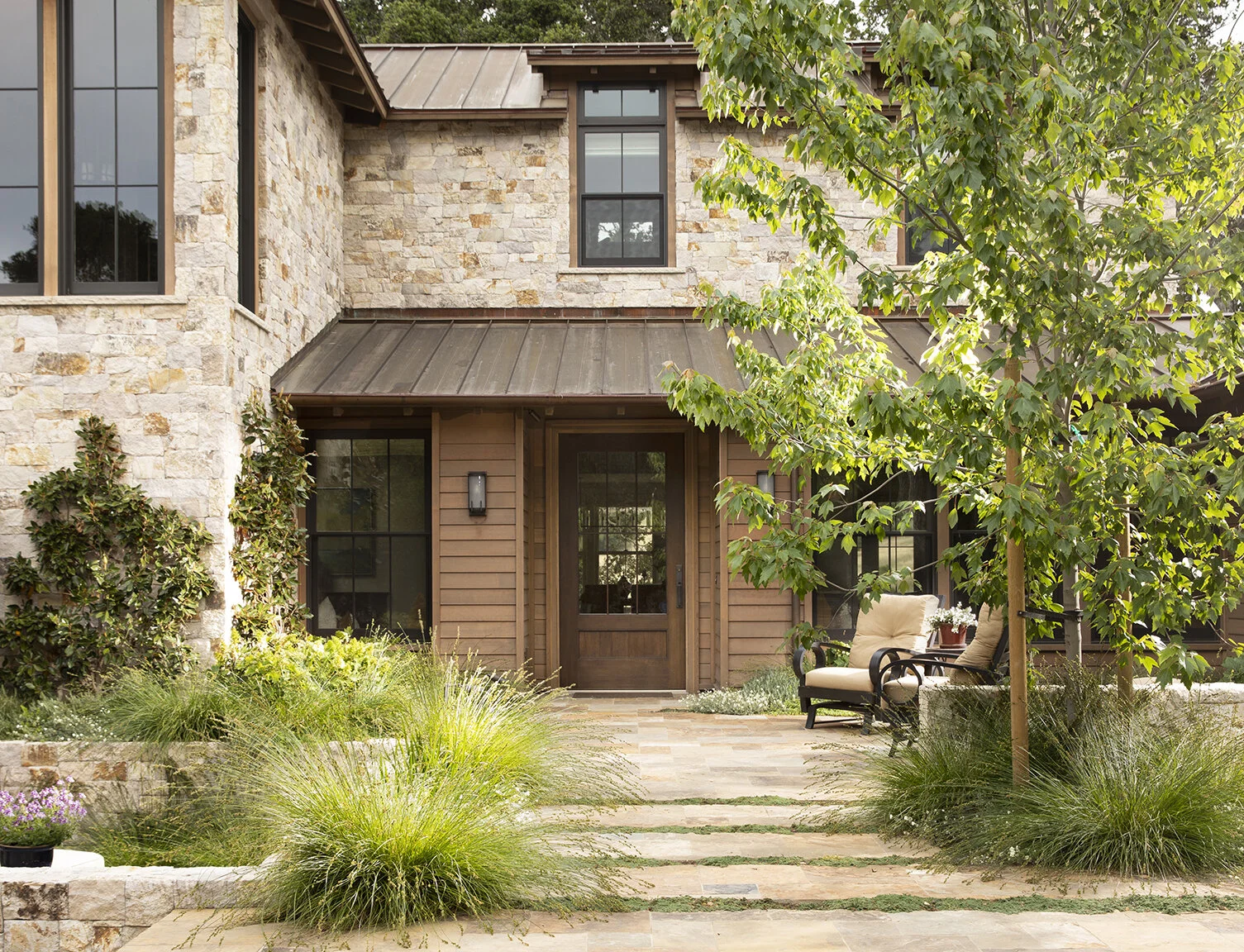 The buff-colored paving stones anchor a rustic seating area around the firepit.