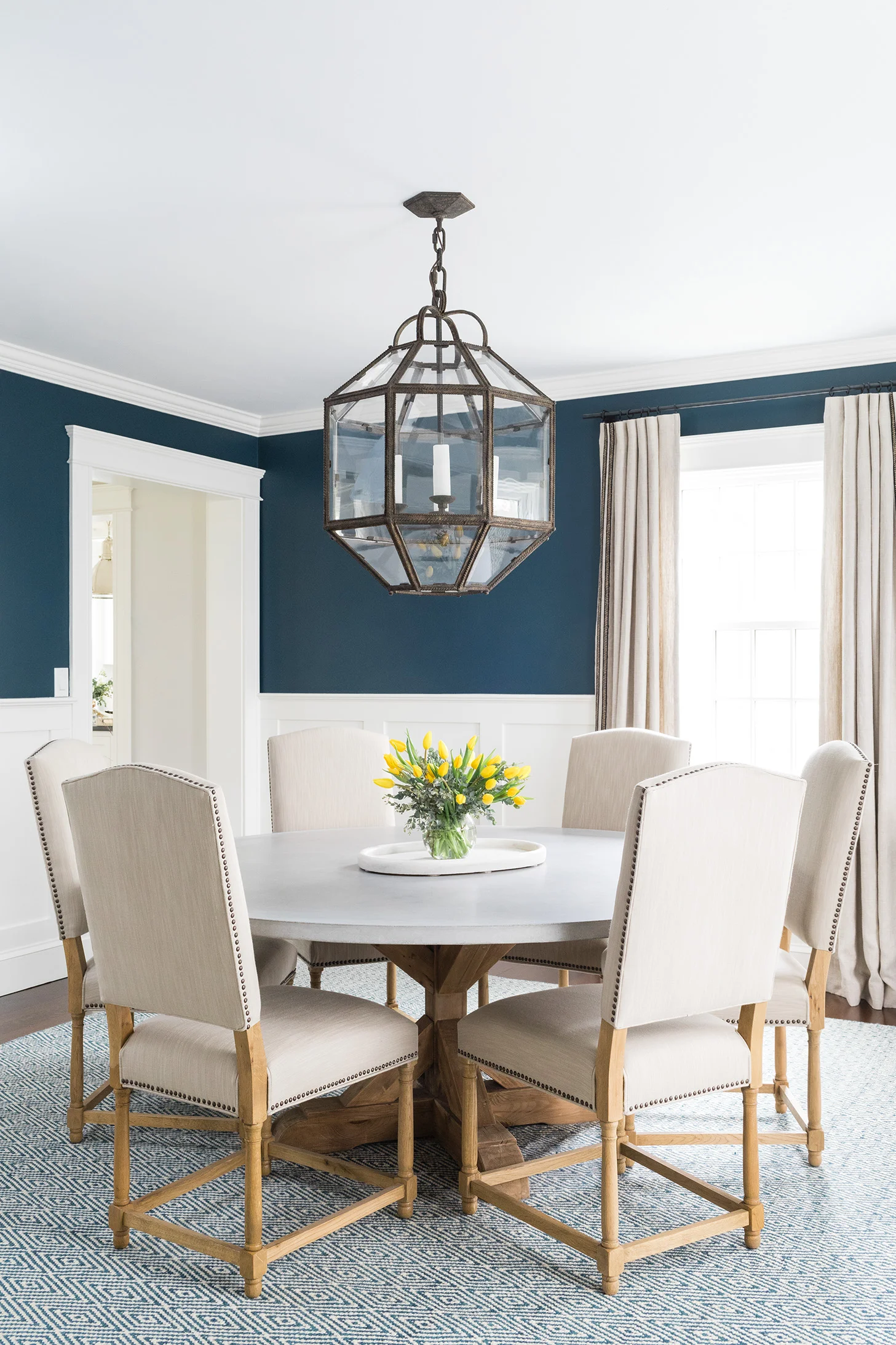 dining room with navy walls and round table - Huffard House Interior Design