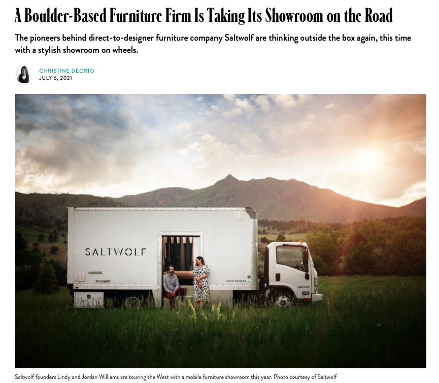 The Saltwolf Furniture mobile showroom with Jordan and Lindy Williams parked in a grassy field with mountains in the background from an article in 5280 Magazine.