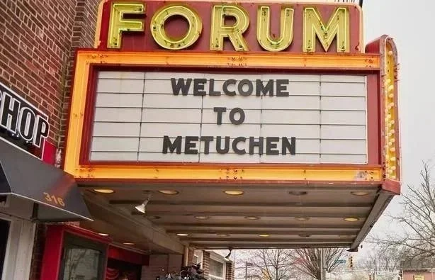 Marquee sign reading "Welcome to Metuchen" in front of a theater named "Forum."
