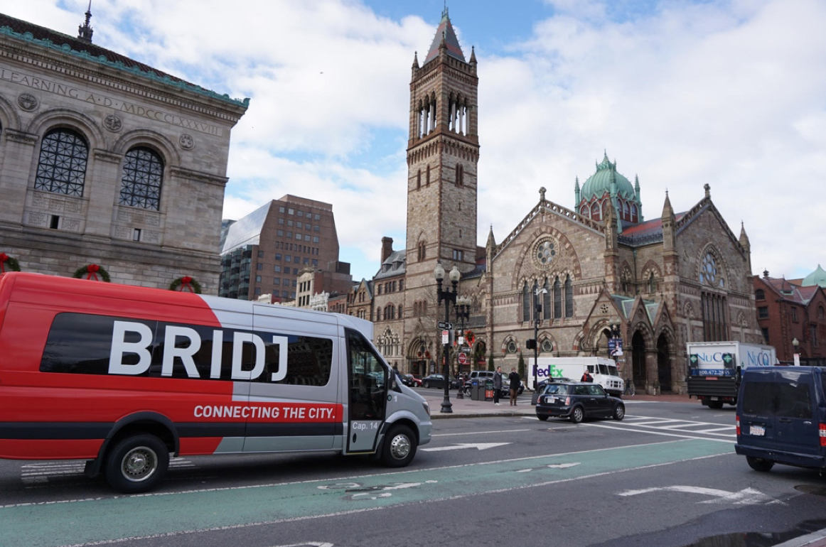 A Bridj van outside of The Boston Public Library. On-demand minibus transportation, on the rise in the Global North, mirrors a form of transport popular in the Global South. (Photo by The Boston Herald)