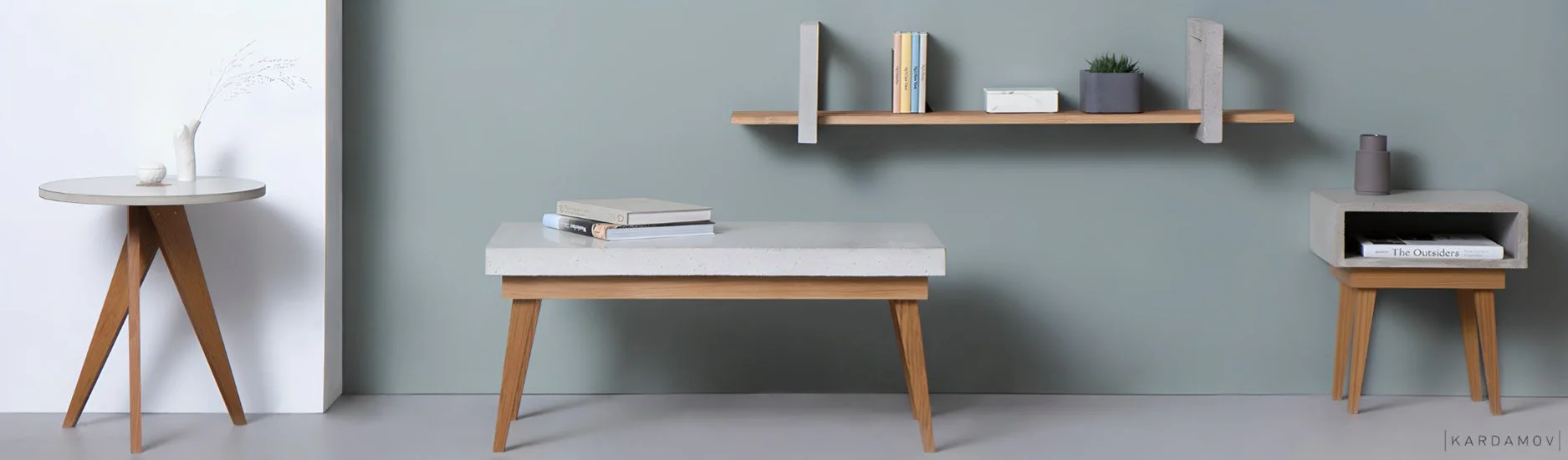 Handcrafted concrete and oak wall shelf and concrete coffee table with oak legs in a minimalist living room setting.