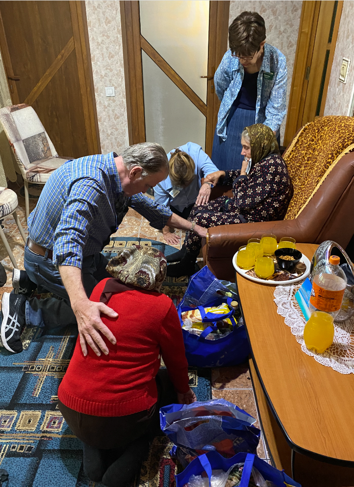Fogwell team praying over widow in Romania Oct 2022.png