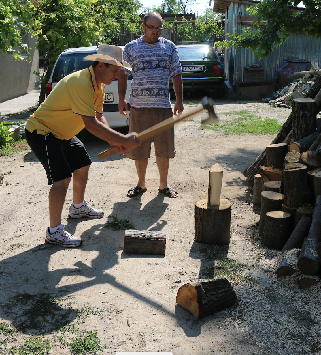 Pastor Peter using Ax to chop Firewood.png