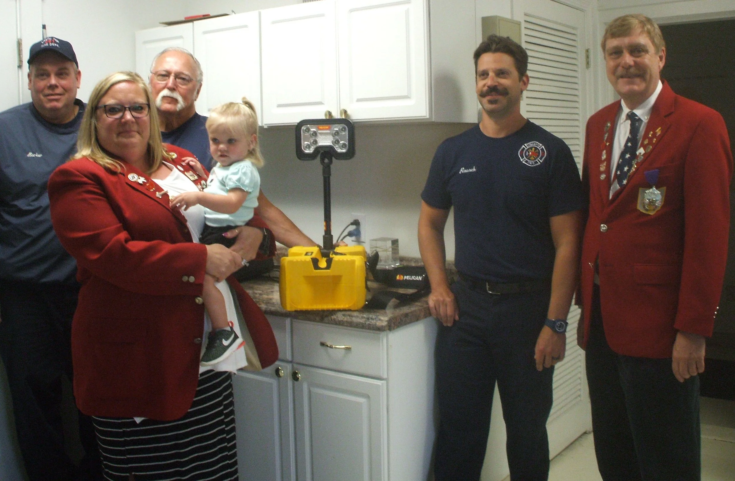 Shown presenting the Lighting system to the Fire Department are from left to right are: Firefighter Dale Barker, Exalted Ruler Billie Jo Humble (holding Autumn), Liberty Township Fire Chief Lloyd Segner, Firefighter/Medic Jeremy Rausch, and Community Service Chairman Kermit Morse, III