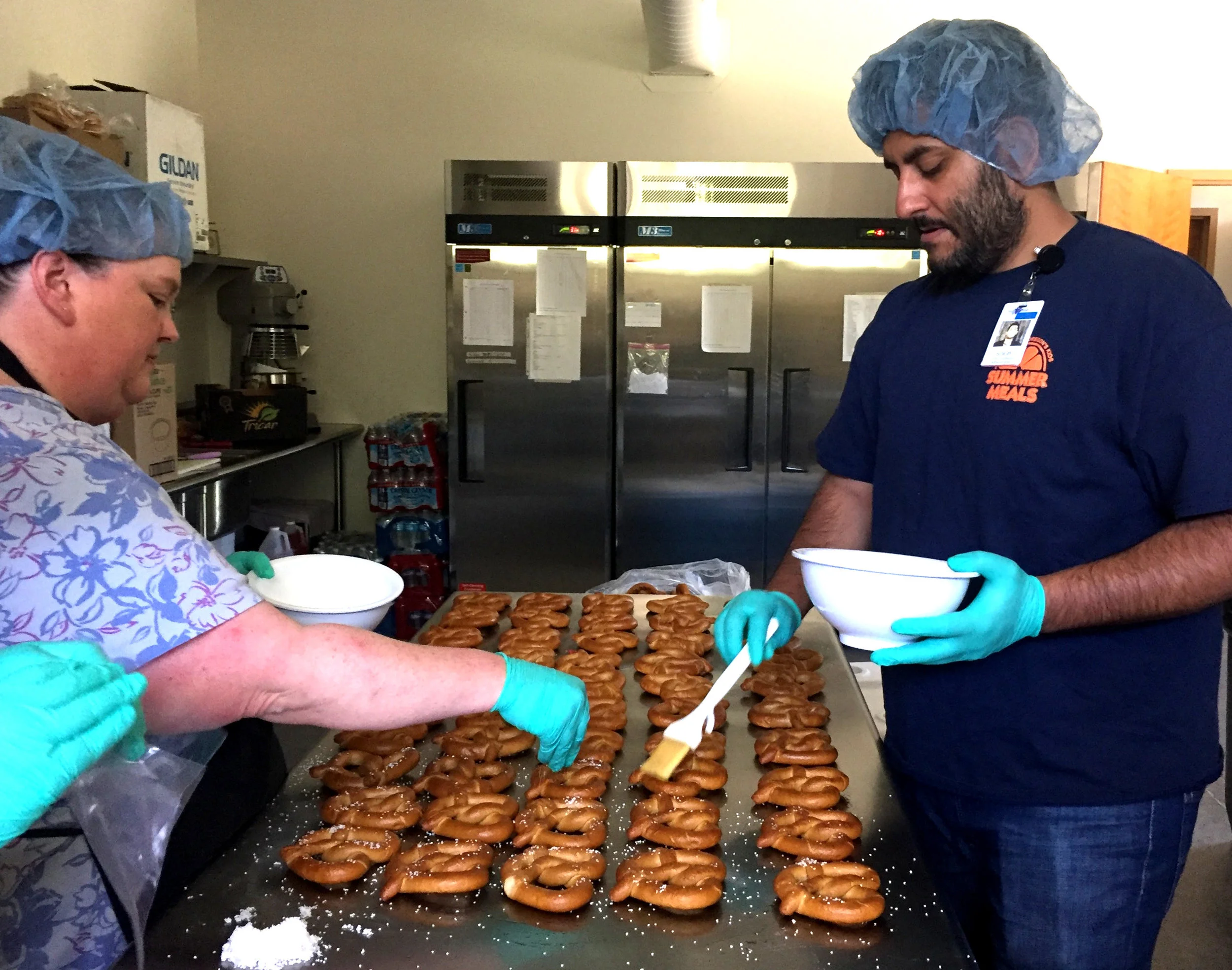 Outback Strong Summer Lunch Program cook Rebecca McMahan, left, and program coordinator Arvinder Singh prepare pretzels for a Wednesday lunch. ( Brooke Kelleher photo | FoodCorps )