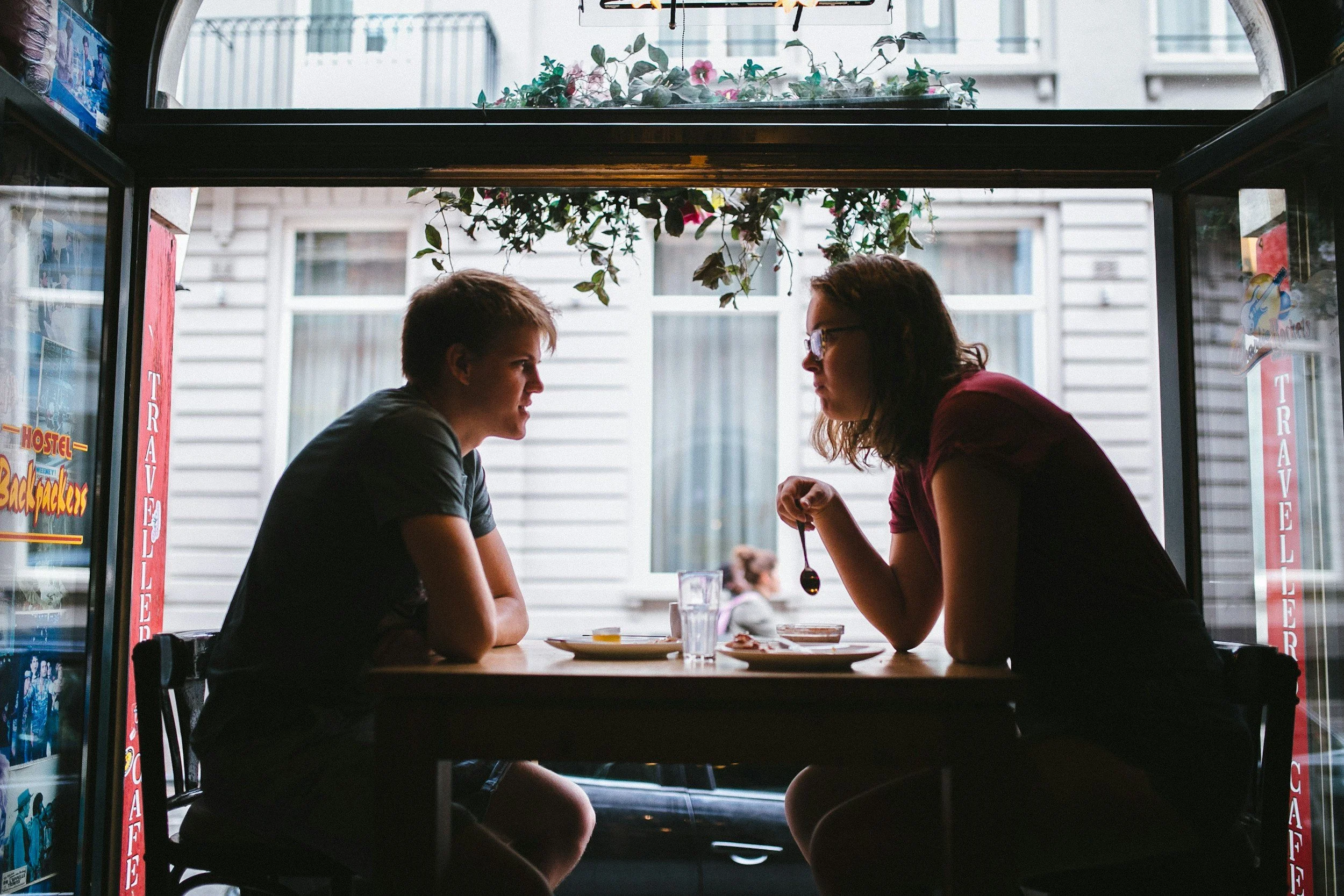 A couple sitting down having a meal, and talking through a conflict in a calm way.