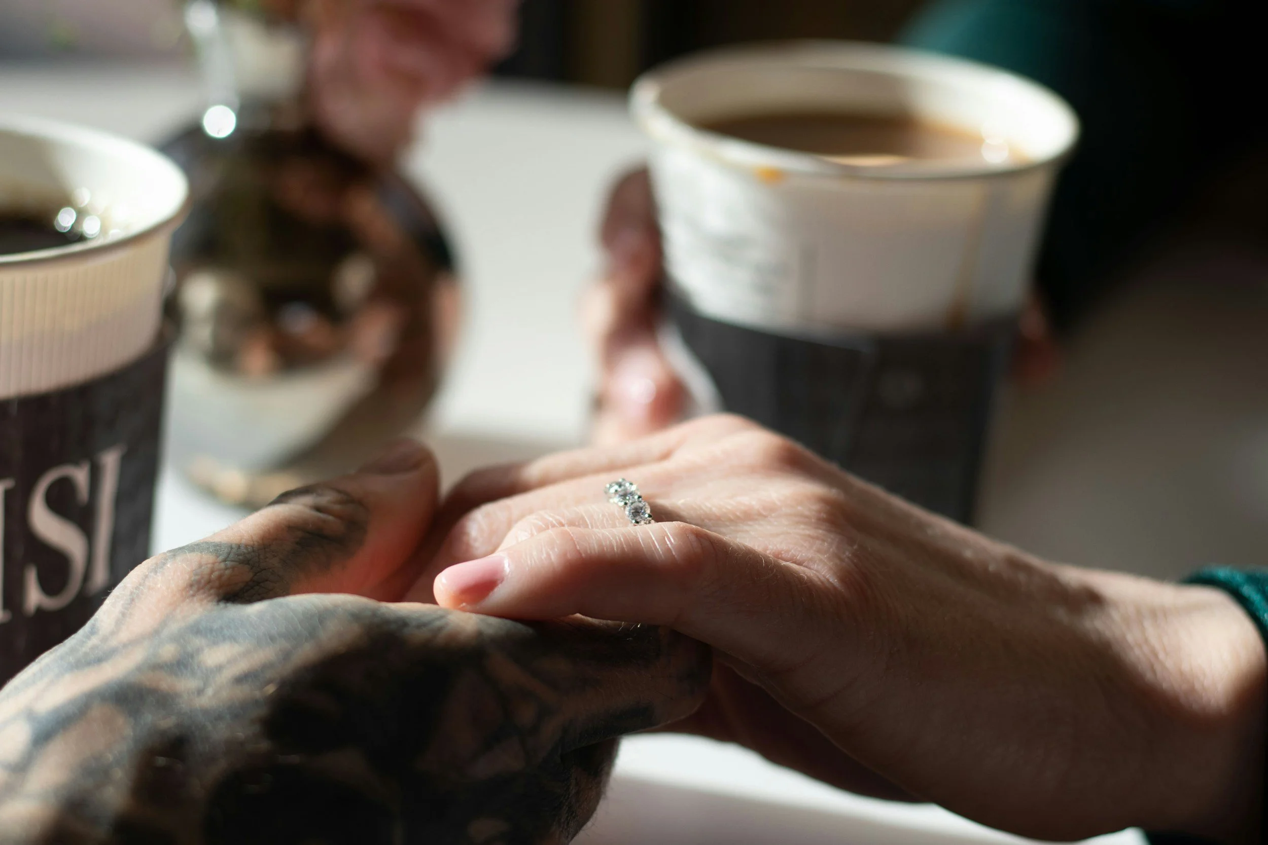 Two hands, implying marriage, sitting down having coffee, connecting about shared goals and values