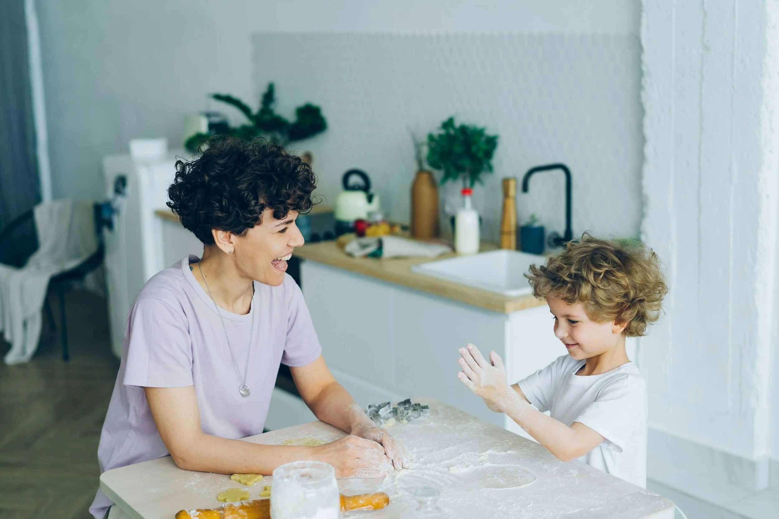 Mom and son sitting down making cookies