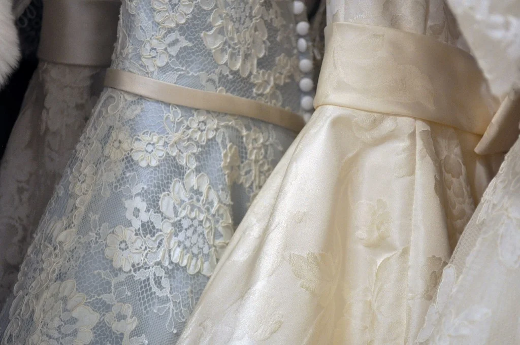 Three wedding dresses hanging on a rack.jpg